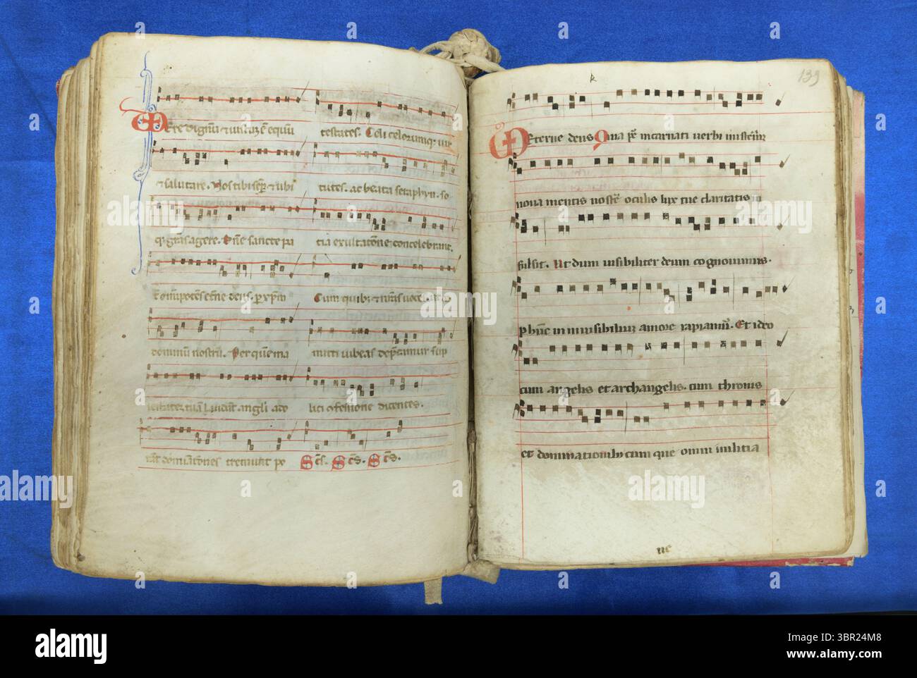 Offene Verbreitung einer lateinischen Gesangshandschrift aus dem 13. Jahrhundert mit quadratischer Notation auf vierzeiligen Notenblättern und rubrizierten Initialen für liturgische Musik. Stockfoto