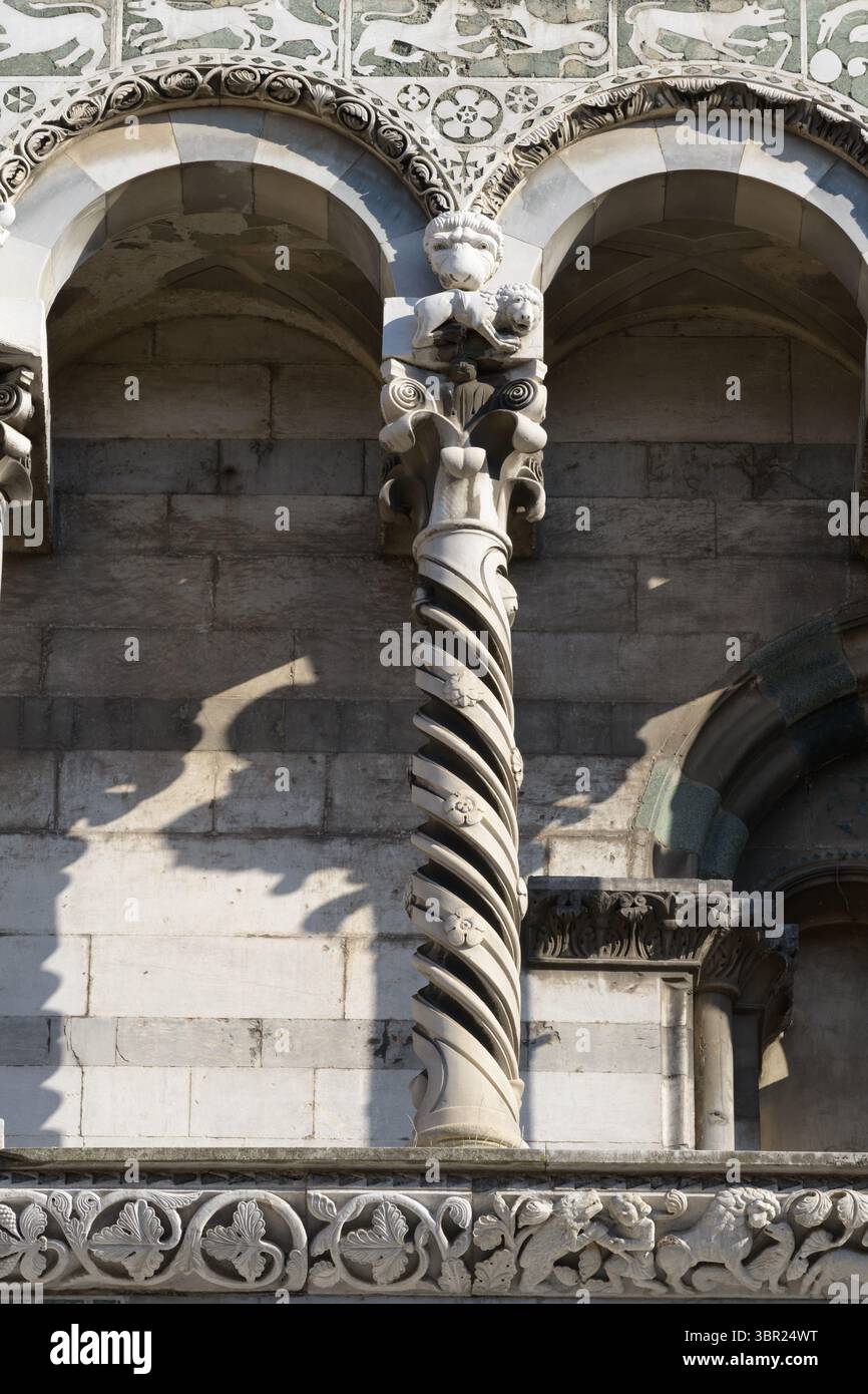 Detail mit verdrehten Säulen und dekorativen Bögen an der oberen Fassade von San Michele in Foro, Lucca, mit romanischen Kapitellen. Stockfoto