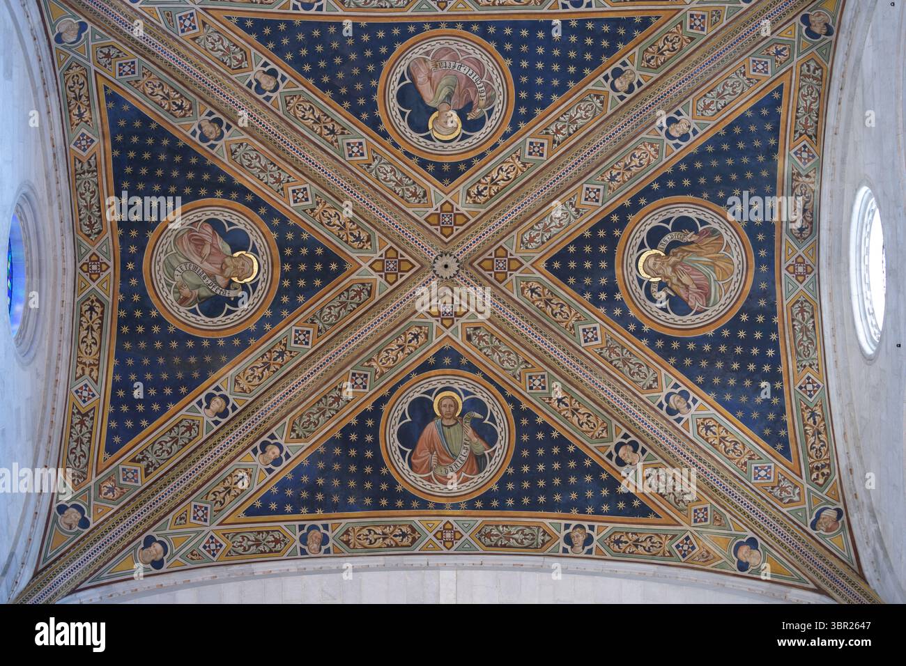 Gemalte Gewölbedecke der Kathedrale San Martino in Lucca, Italien, mit christlicher Ikonographie, Goldverzierungen und Sternen. Stockfoto