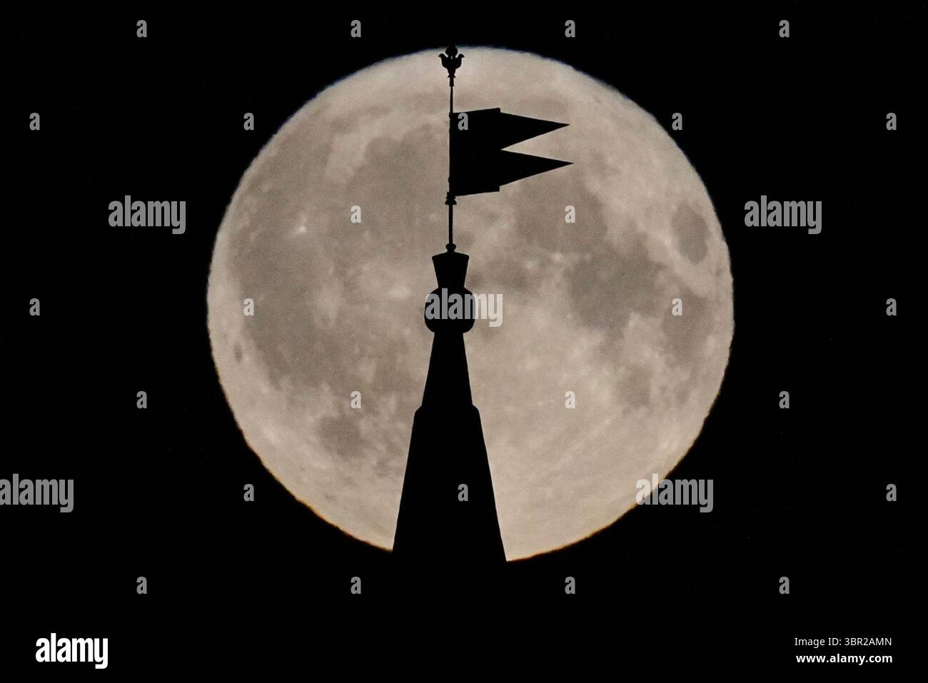 A full moon rises behind a weathervane at Troitskaya Tower of the Kremlin in Moscow, Russia, Thursday, July 10, 2025. (AP Photo/Pavel Bednyakov) Stockfoto