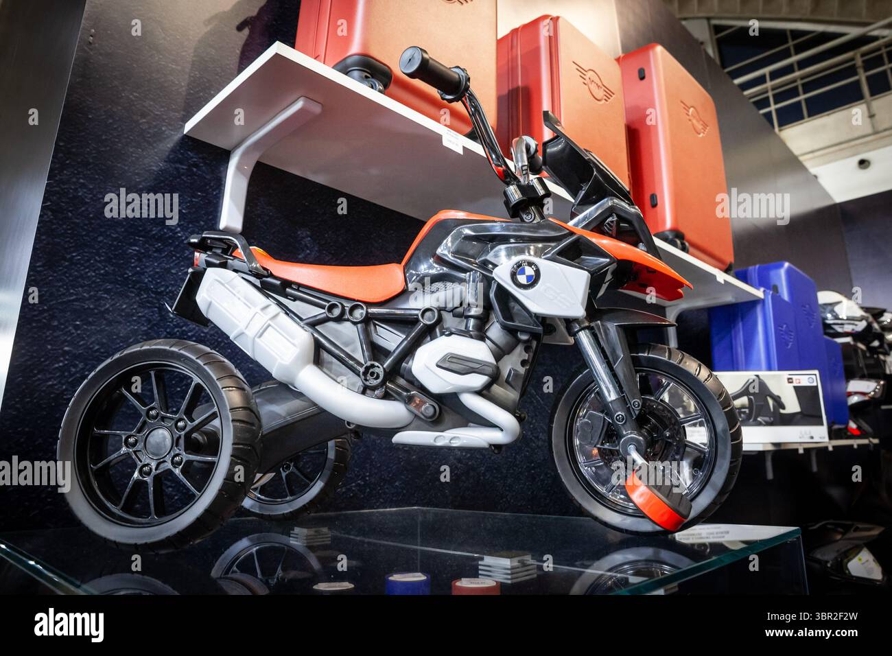 BELGRAD, SERBIEN - 22. MÄRZ 2025: Ein Kinderdreirad im Stil eines BMW GS Abenteuermotorrads, gezeigt auf einem Glasregal in einem Kinderregal Stockfoto