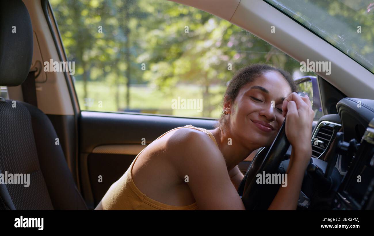 Glückliche afroamerikanische Frau Käuferin weibliche Sit Luxus neues Auto umarmt Rad Lenkung Besitzer Auto kaufen Genießen Geschäftsfrau Fahrzeug umarmen Stockfoto