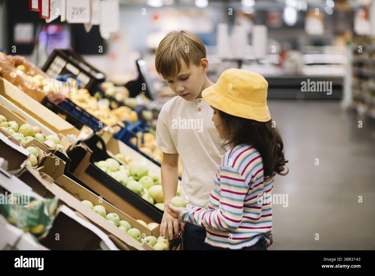 Kinder kleine Suesses Maedchen und Teenager Junge Einkaufen für frisches Bio-Obst und Gemuese im Supermarkt Stockfoto