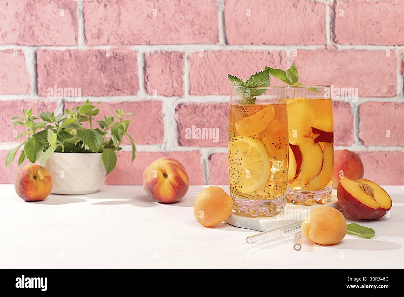 Eiskalte hausgemachte Limonade oder Cocktail mit Minze, Aprikosen, Pfirsichen, Chiasamen und Zitrusfrüchten, Rezept für ein erfrischendes Sommergetränk, Detox Diät und Stockfoto