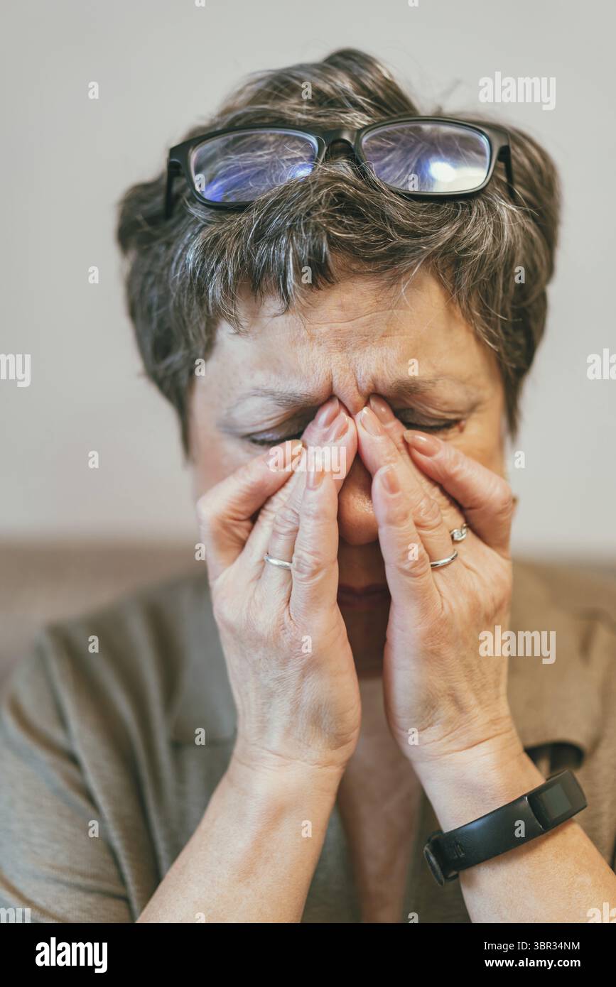 Nahaufnahme der älteren Dame fühlen sich ungesund Touch Massage Augen mit starken Migränesymptomen oder Kopfschmerzen, ältere Frau nehmen Brillen, die an d leiden Stockfoto