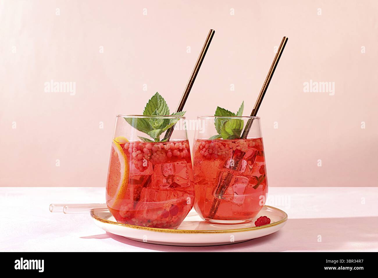Kalter hausgemachter Limonade-Cocktail, Mojito mit Minze, Himbeere und Früchten auf einem sonnigen Tisch, erfrischendes Sommergetränk Rezept, Detox Diät und Gewichtsverlust c Stockfoto