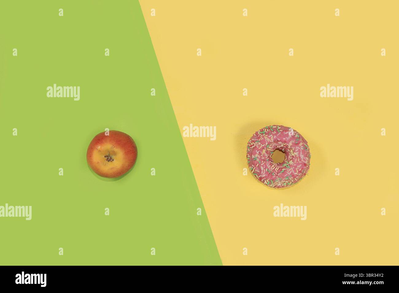 Apfel und Donut auf einem hellen Hintergrund. Minimales Konzept der Gewichtsabnahme, gesunder Lebensstil, Ablehnung ungesunder Ernährung. Das Konzept der Detox-Diät und Stockfoto