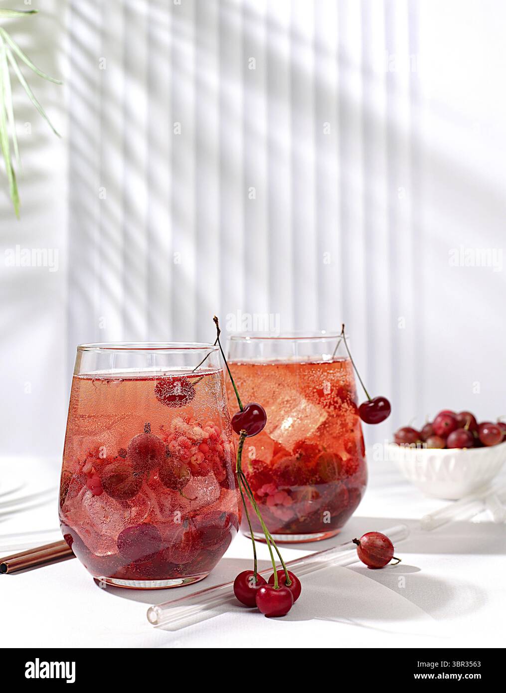 Kalter hausgemachter Limonade-Cocktail, Mojito mit Minze, Kirsche und Stachelbeere auf einem sonnigen Tisch, erfrischendes Sommergetränk-Rezept, Entgiftungsdiät und Gewichtsverlust Stockfoto