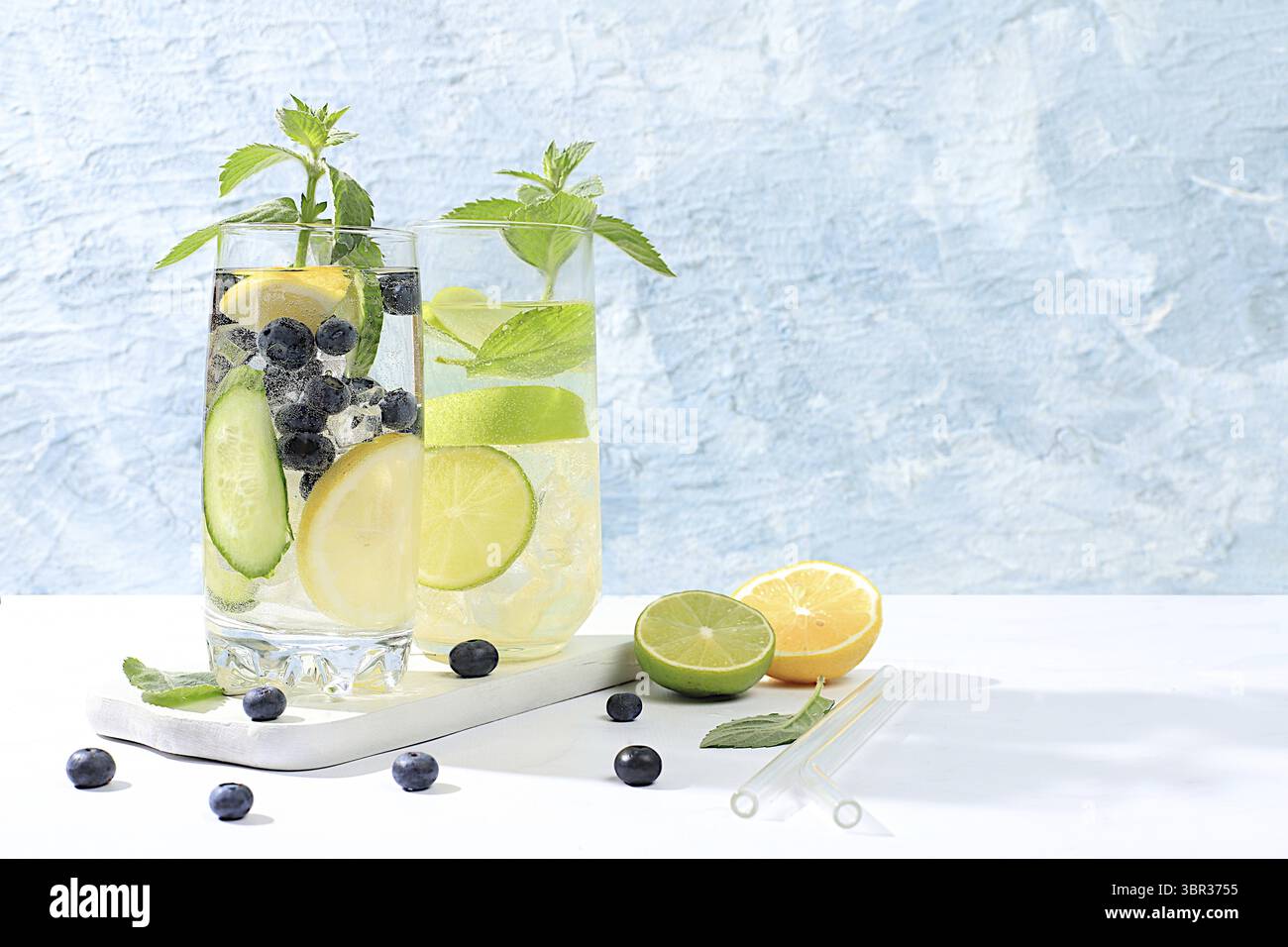 Entgiftungswasser mit Zitronen-, Gurken-, Heidelbeeren- und Minzaromen auf hellem Hintergrund. Ein erfrischender hausgemachter Limonade-Cocktail im Sommer. Fruchtsaft und in Stockfoto