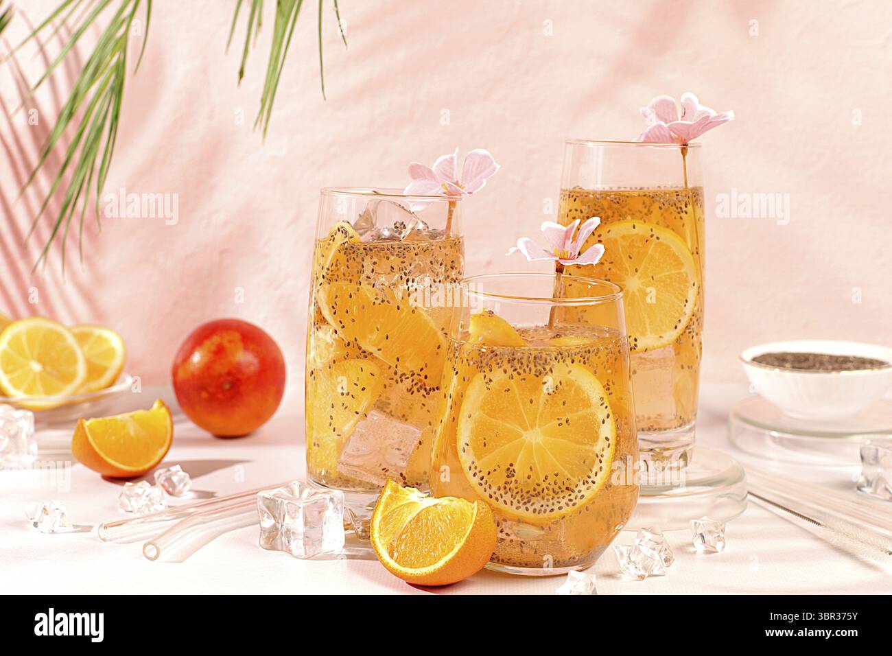 Modernes Stillleben mit Zitrusfrüchten. Diät-veganer Cocktail mit Chiasamen, Orange, Limette, Veilchen und Eis. Detox-Diät und Gewichtsreduktion-Konzept. Sommerba Stockfoto