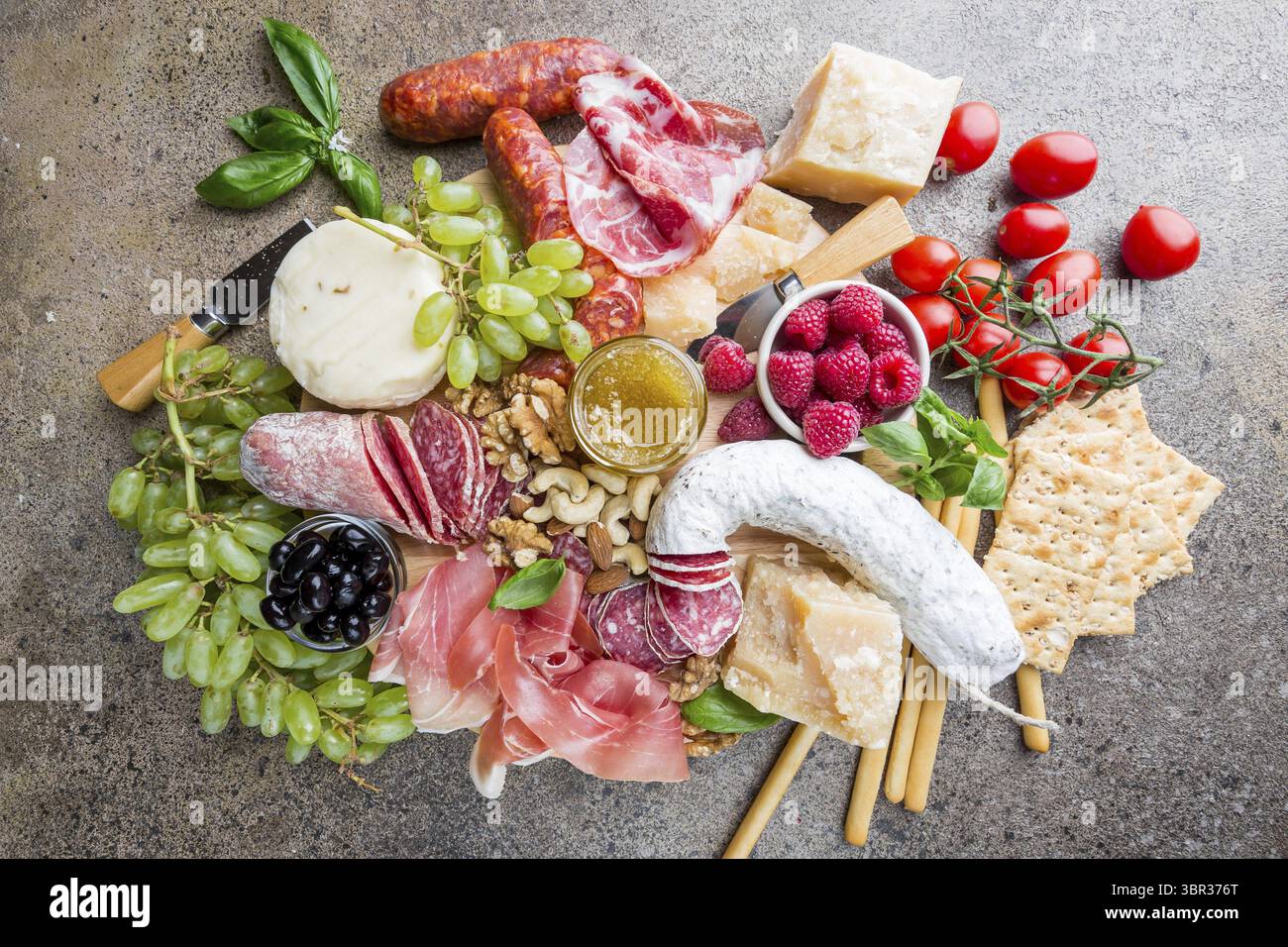 Mix aus verschiedenen Snacks und Vorspeisen. Spanische Tapas oder italienischen Wein auf einer Holzplatte. Tapas Bar. Nüsse, Oliven, Wurst, Käse, Schinken, Tomaten Stockfoto