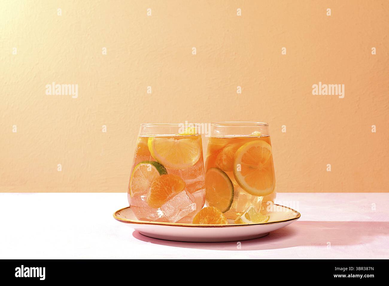 Detox Drink mit Zitrone, Minze, Limette und Orange auf einem Leuchttisch, Mojito oder Cocktail verbessert Stoffwechsel, fördert den Gewichtsverlust und stärkt die Immunität Stockfoto