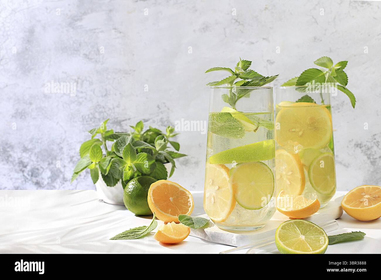 Diät veganer Cocktail mit Zitrusfrüchten, Entgiftungswasser, Mojito mit Zitrone, Limette, Orange, Minze und grüner Apfel. Detox Diät und Gewichtsverlust Konzept, gesunde Leben Stockfoto