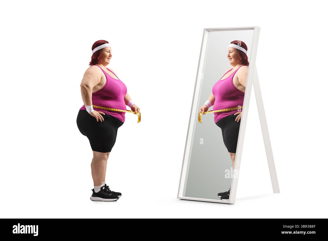 Übergewichtige Frau mit einem Maßband auf einer Waage vor einem Spiegel isoliert auf weißem Hintergrund Stockfoto