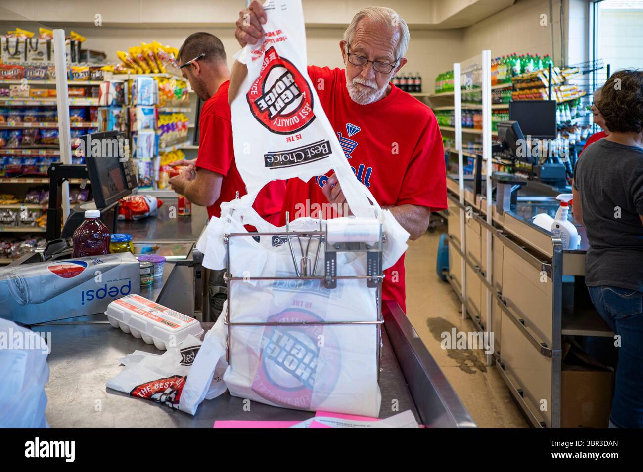 8. Juli 2020, Jewell, Iowa, USA: RICK KNOLL, ein Arbeiter auf dem Jewell Market hat die Lebensmittel eines Kunden eingepackt. Der einzige Supermarkt in Jewell, einer kleinen Gemeinde im Zentrum von Iowa, wurde 2019 geschlossen. Es diente vier Gemeinden im Umkreis von 20 Meilen um Jewell. Einige Bewohner der Stadt gründeten eine Genossenschaft, um den Laden wieder zu eröffnen. Sie verkauften Aktien an die Co-op und hielten Spendenaktionen im Frühjahr ab. Die Organisatoren sammelten etwa 225.000 US-Dollar und kauften den Laden, der am 8. Juli wieder eröffnet wurde. Vor der Wiedereröffnung war Jewell sieben Monate lang eine „Essenswüste“. Das USDA definiert ländliche Lebensmittelwüsten als mindestens fünf Stockfoto