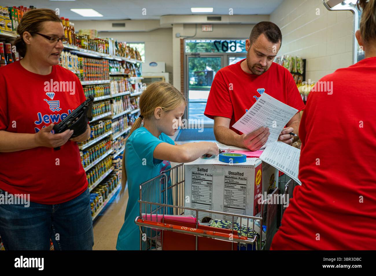 8. Juli 2020, Jewell, Iowa, USA: Umgeben von Arbeitern im Lebensmittelgeschäft, verkauft KAYLEY ZANKER Waren in der Produktionsabteilung des Jewell Market. Der einzige Supermarkt in Jewell, einer kleinen Gemeinde im Zentrum von Iowa, wurde 2019 geschlossen. Es diente vier Gemeinden im Umkreis von 20 Meilen um Jewell. Einige Bewohner der Stadt gründeten eine Genossenschaft, um den Laden wieder zu eröffnen. Sie verkauften Aktien an die Co-op und hielten Spendenaktionen im Frühjahr ab. Die Organisatoren sammelten etwa 225.000 US-Dollar und kauften den Laden, der am 8. Juli wieder eröffnet wurde. Vor der Wiedereröffnung war Jewell sieben Monate lang eine „Essenswüste“. Th Stockfoto