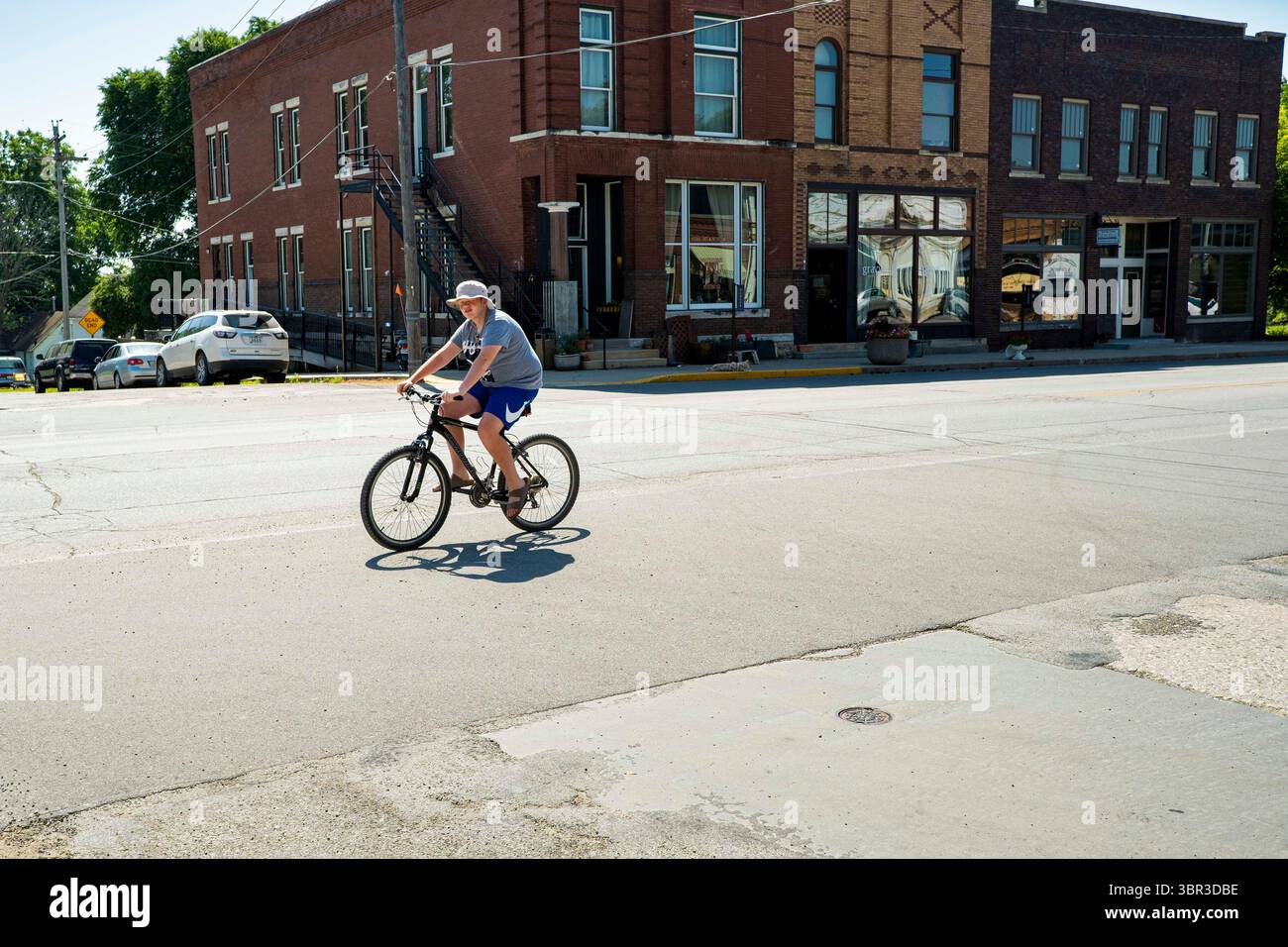 8. Juli 2020, Jewell, Iowa, USA: Eine Person fährt mit dem Fahrrad durch die Innenstadt von Jewell, IA. Der einzige Supermarkt in Jewell, einer kleinen Gemeinde im Zentrum von Iowa, wurde 2019 geschlossen. Es diente vier Gemeinden im Umkreis von 20 Meilen um Jewell. Einige Bewohner der Stadt gründeten eine Genossenschaft, um den Laden wieder zu eröffnen. Sie verkauften Aktien an die Co-op und hielten Spendenaktionen im Frühjahr ab. Die Organisatoren sammelten etwa 225.000 US-Dollar und kauften den Laden, der am 8. Juli wieder eröffnet wurde. Vor der Wiedereröffnung war Jewell sieben Monate lang eine „Essenswüste“. Das USDA definiert ländliche Lebensmittelwüsten als mindestens 500 Menschen in A Stockfoto