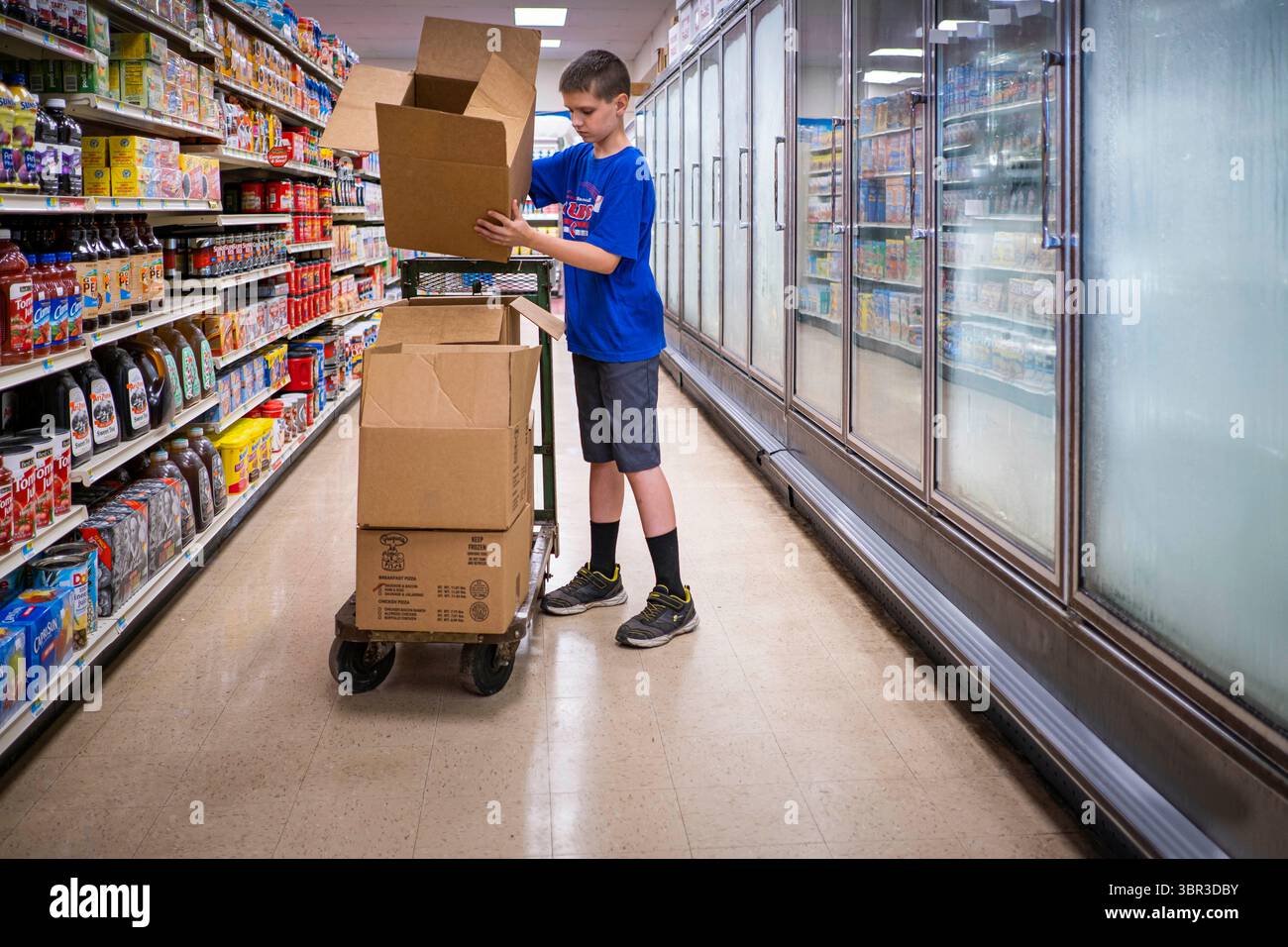 8. Juli 2020, Jewell, Iowa, USA: TREVOR ZANKER zerlegt Kisten im Gefriergang des Jewell Market. Der einzige Supermarkt in Jewell, einer kleinen Gemeinde im Zentrum von Iowa, wurde 2019 geschlossen. Es diente vier Gemeinden im Umkreis von 20 Meilen um Jewell. Einige Bewohner der Stadt gründeten eine Genossenschaft, um den Laden wieder zu eröffnen. Sie verkauften Aktien an die Co-op und hielten Spendenaktionen im Frühjahr ab. Die Organisatoren sammelten etwa 225.000 US-Dollar und kauften den Laden, der am 8. Juli wieder eröffnet wurde. Vor der Wiedereröffnung war Jewell sieben Monate lang eine „Essenswüste“. Das USDA definiert ländliche Lebensmittelwüsten als „bei“ Stockfoto