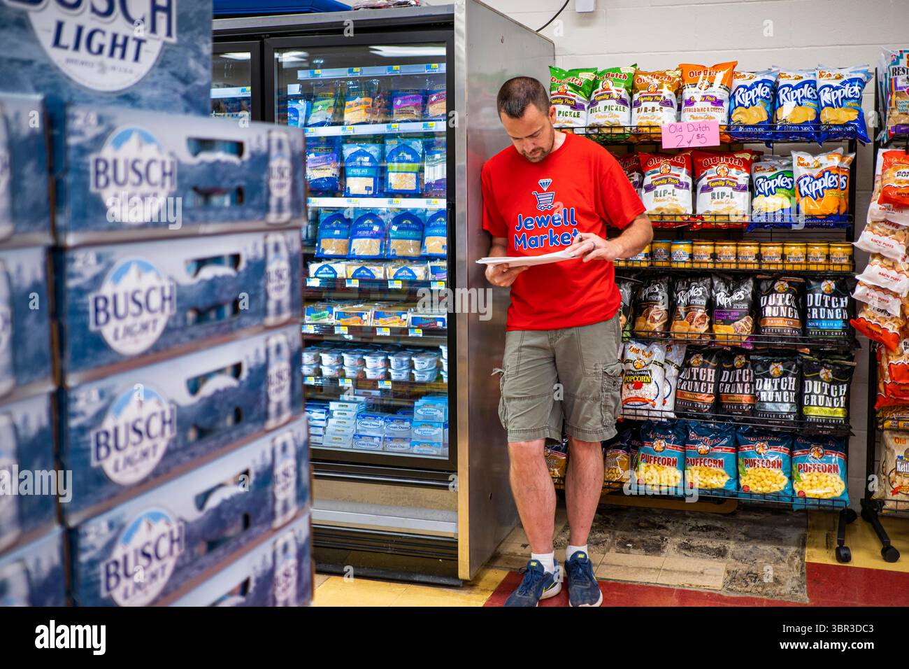 Juli 2020, Jewell, Iowa, USA: GARREN ZANKER, manager des Jewell Market, prüft am Eröffnungstag einen Inventarbogen. Der einzige Supermarkt in Jewell, einer kleinen Gemeinde im Zentrum von Iowa, wurde 2019 geschlossen. Es diente vier Gemeinden im Umkreis von 20 Meilen um Jewell. Einige Bewohner der Stadt gründeten eine Genossenschaft, um den Laden wieder zu eröffnen. Sie verkauften Aktien an die Co-op und hielten Spendenaktionen im Frühjahr ab. Die Organisatoren sammelten etwa 225.000 US-Dollar und kauften den Laden, der am 8. Juli wieder eröffnet wurde. Vor der Wiedereröffnung war Jewell sieben Monate lang eine „Essenswüste“. Das USDA definiert ländliche Lebensmittelwüsten A Stockfoto