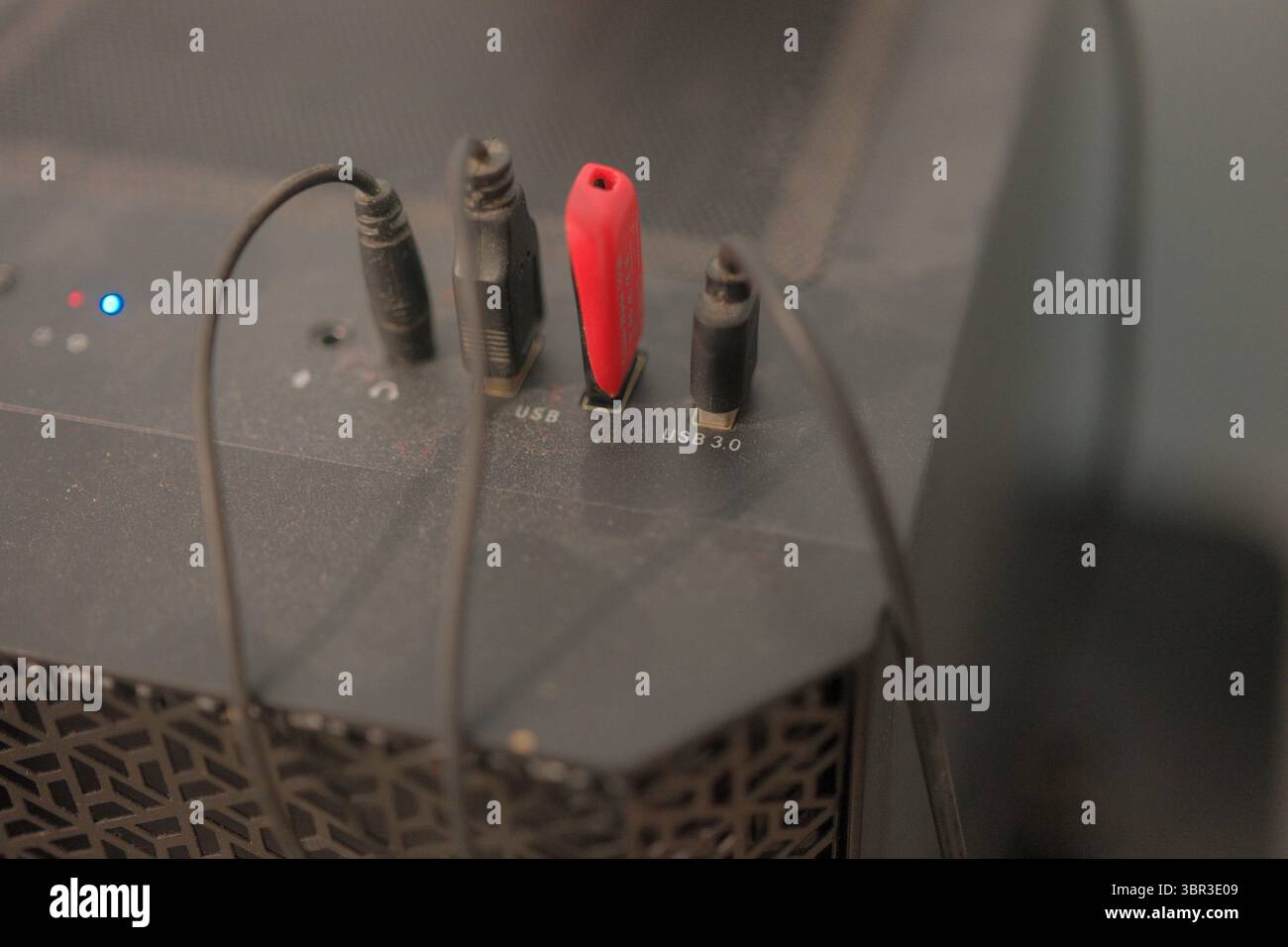 Auf den hinteren Netzwerkanschlüssen lagert sich eine Staubschicht ab, die auf übersehene Abwehrmechanismen und die leise Spannung unsichtbarer Cyberbedrohungen gegenüber wichtigen Systemen hindeutet. Stockfoto