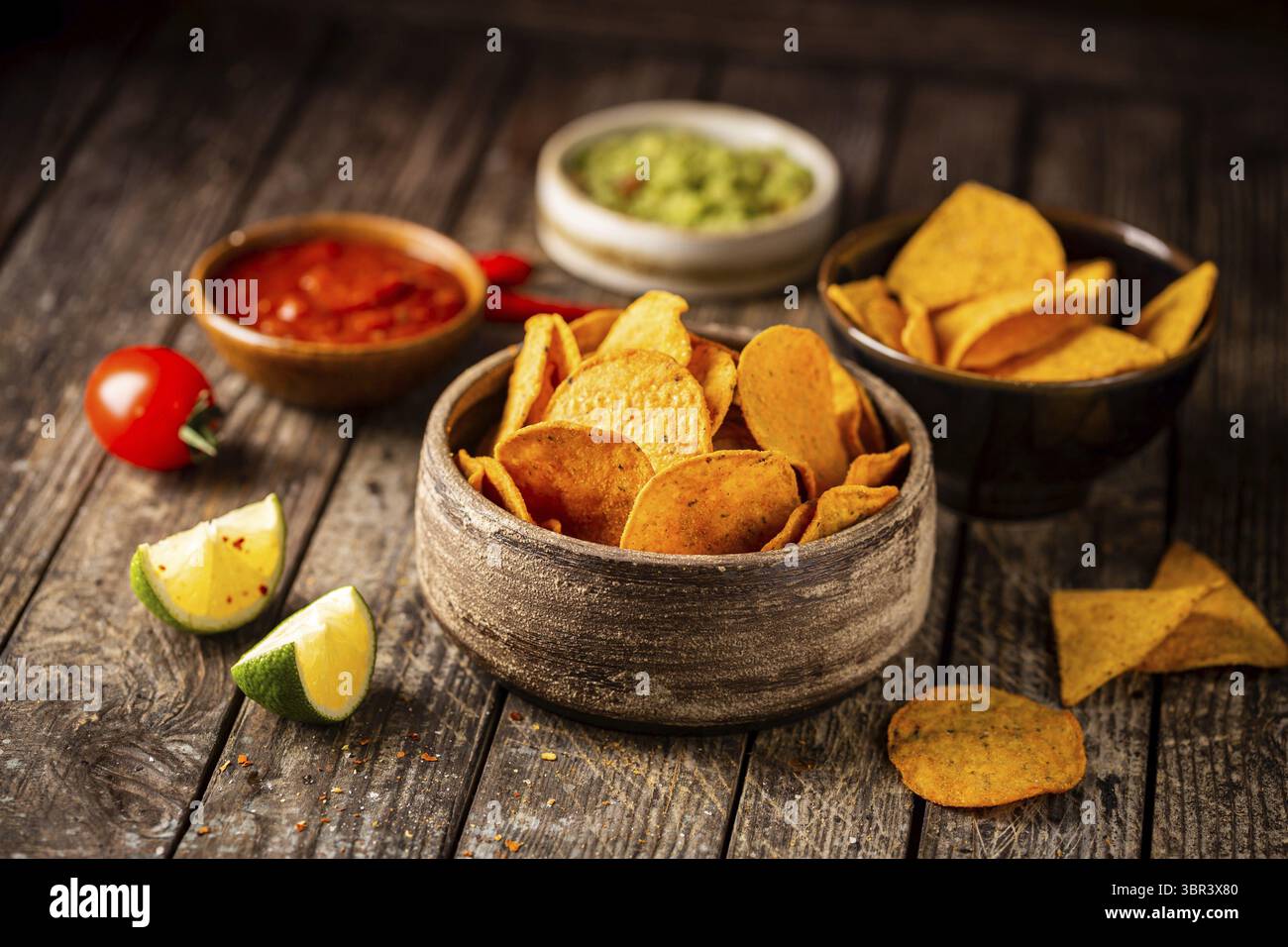 Zwei Biowls gelber Mais Tortilla Nachos Chips mit Salsa Und Guacamole Sauce auf Holzgrund Stockfoto