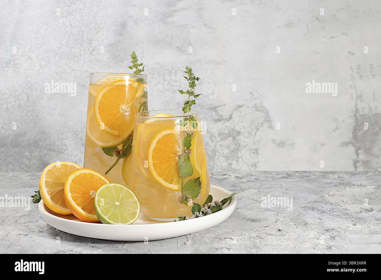 Diät veganer Cocktail mit Zitrusfrüchten, Entgiftungswasser, Mojito mit Zitrone, Limette, Orange, Minze und grüner Apfel. Detox Diät und Gewichtsverlust Konzept, gesunde Leben Stockfoto