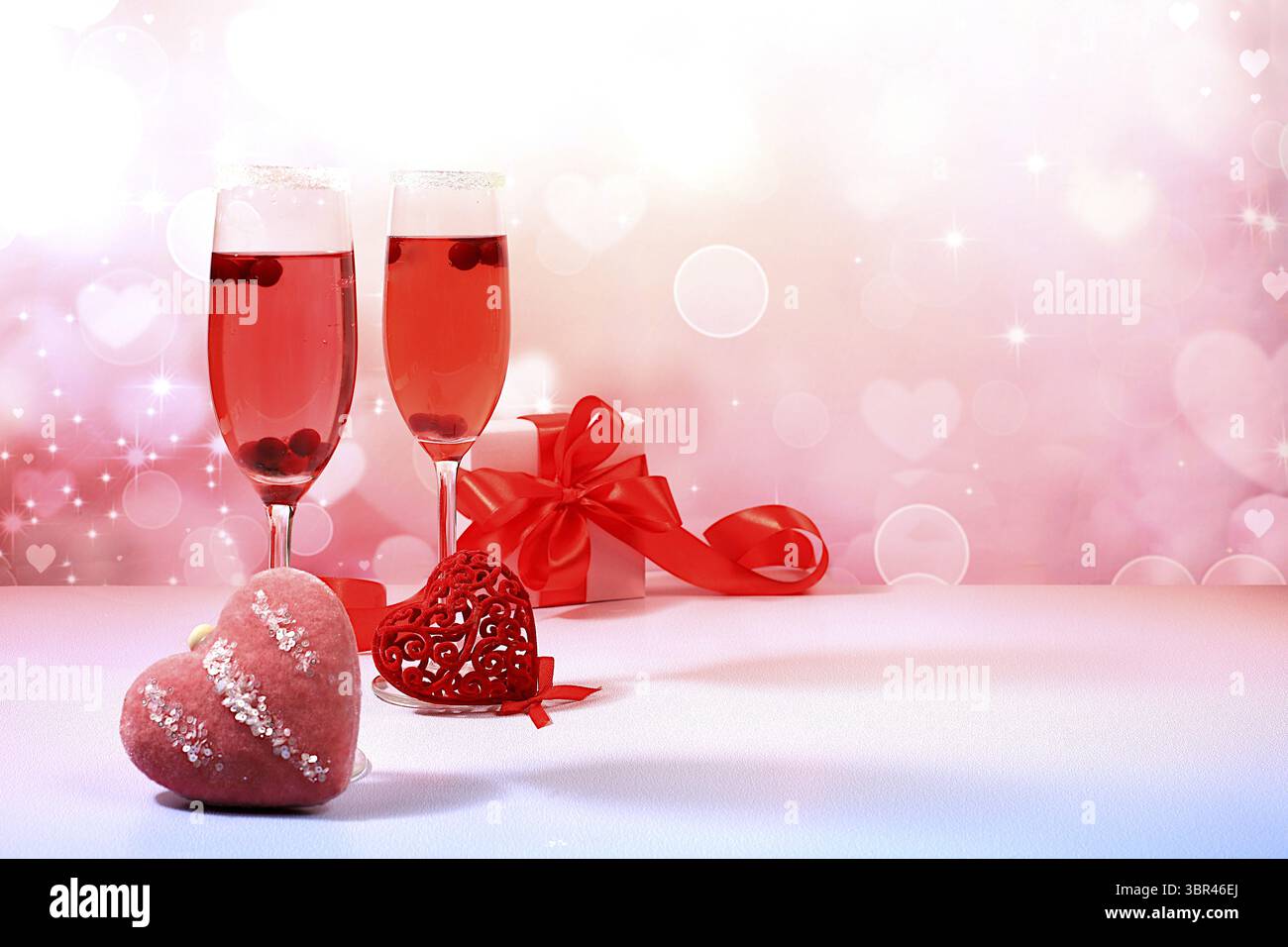 Festlicher alkoholischer Cocktail Mimosa mit Preiselbeeren in Gläsern und Liebesherzen, Valentinstag-Konzept, alkoholische Getränke auf einer Party, Bar und Restaurant Stockfoto