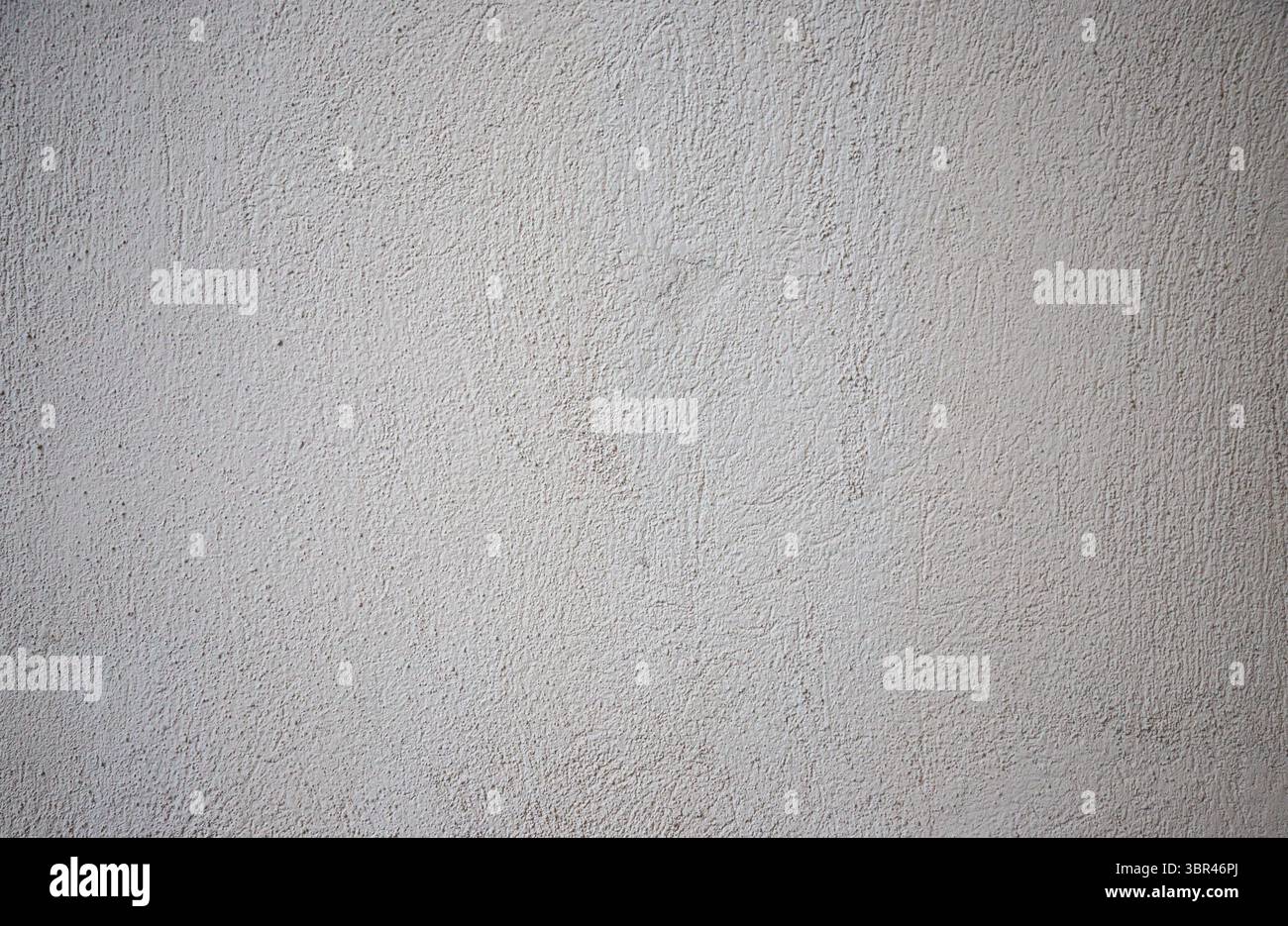 Die Oberfläche zeigt eine glatte, strukturierte graue Wand mit Farbvariationen und Schatten. Dieses Designelement verleiht verschiedenen Modellen ein elegantes, modernes Gefühl Stockfoto