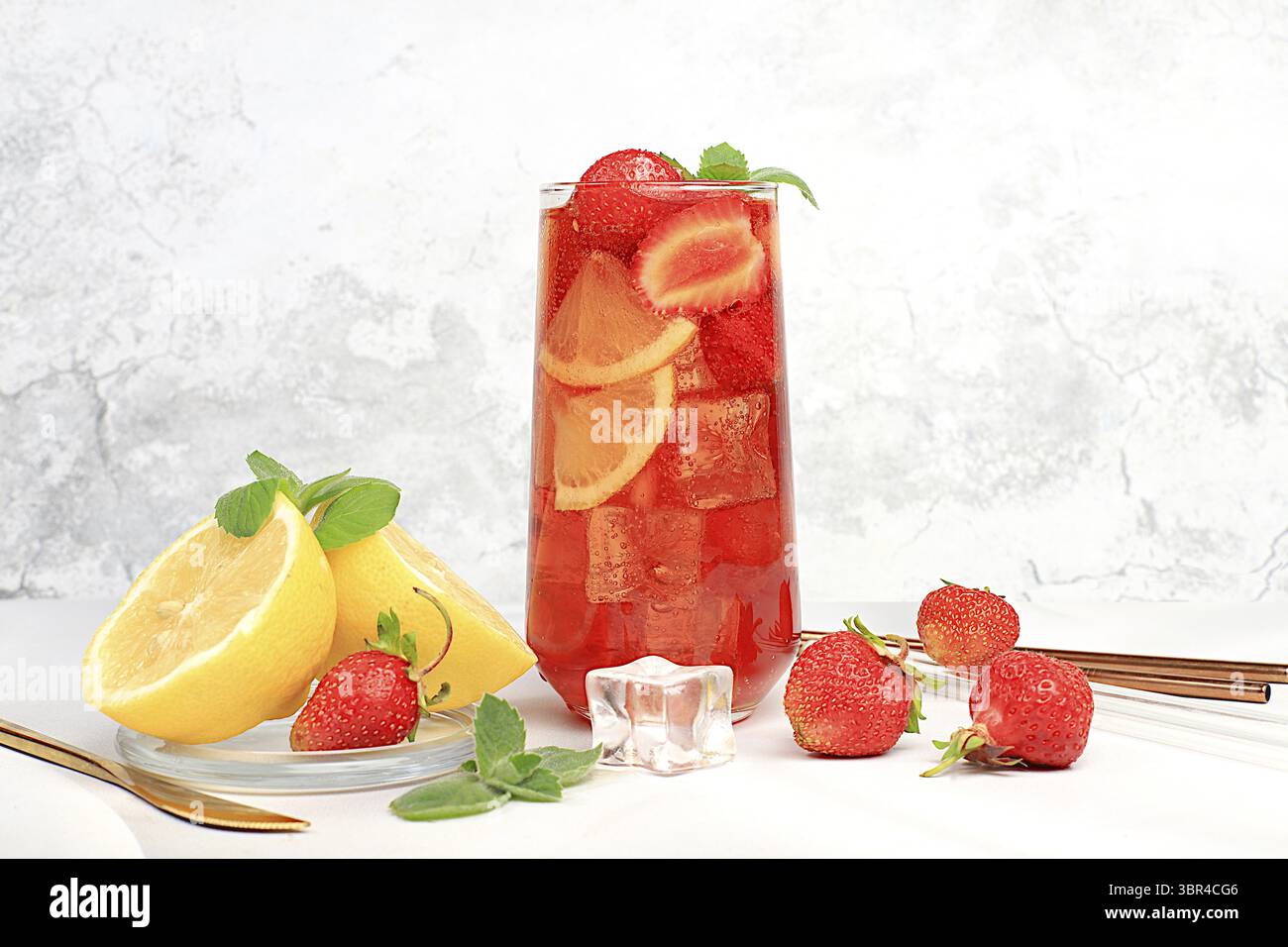 Erdbeere Iced Tea oder Minze Lemon Cocktail ist ein erfrischendes Sommergetränk. Gläser mit Beerenfrucht-Limonade auf einem hellen Betontisch, Detox-Würfel Stockfoto