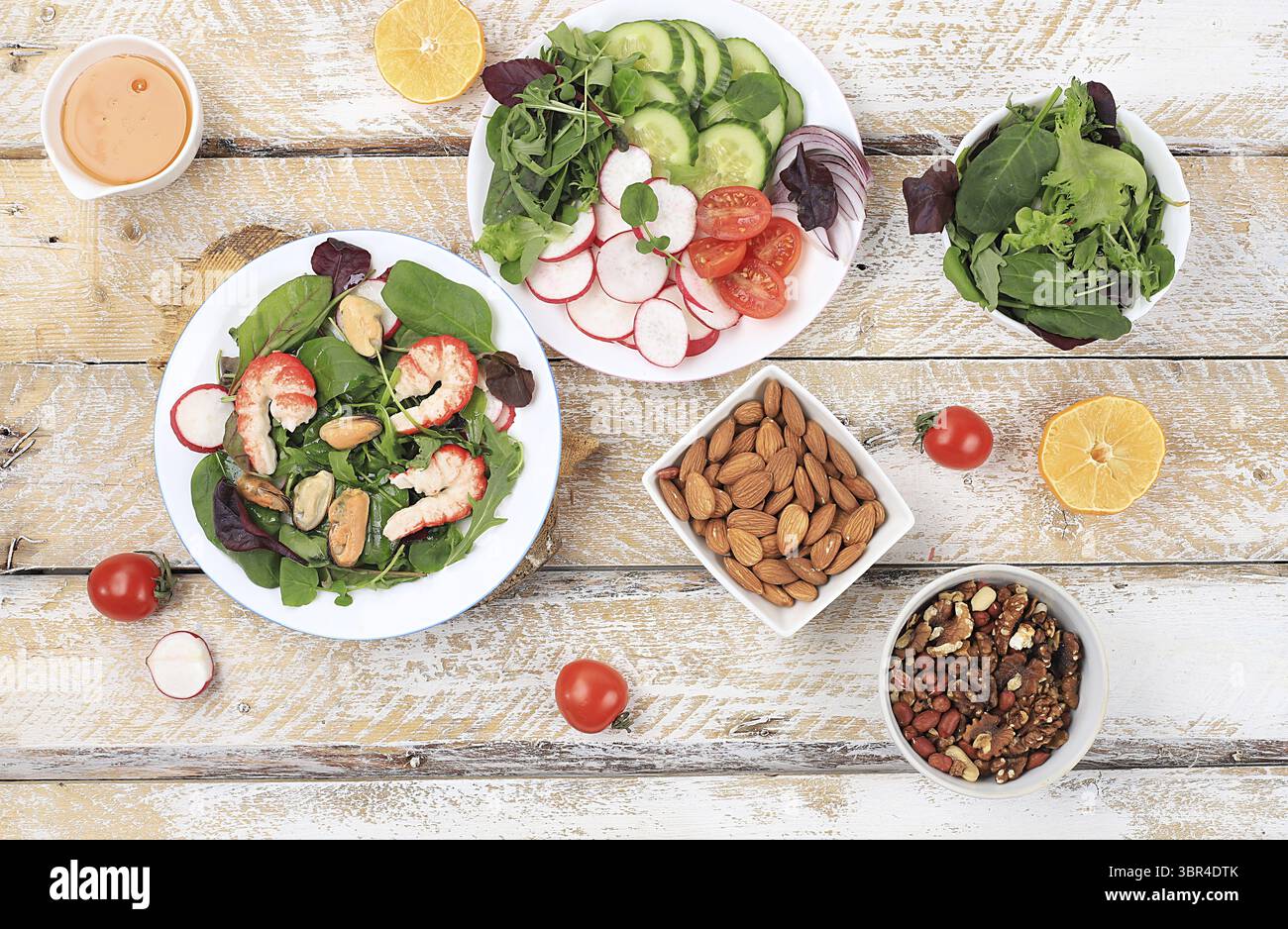 Gemüsesalat mit Garnelen, Gurke, Kirschtomaten, Radieschen, Honig, Nüsse und frische Rucola, gesundes natürliches Frühstück mit Zitrone, Detox Diet con Stockfoto