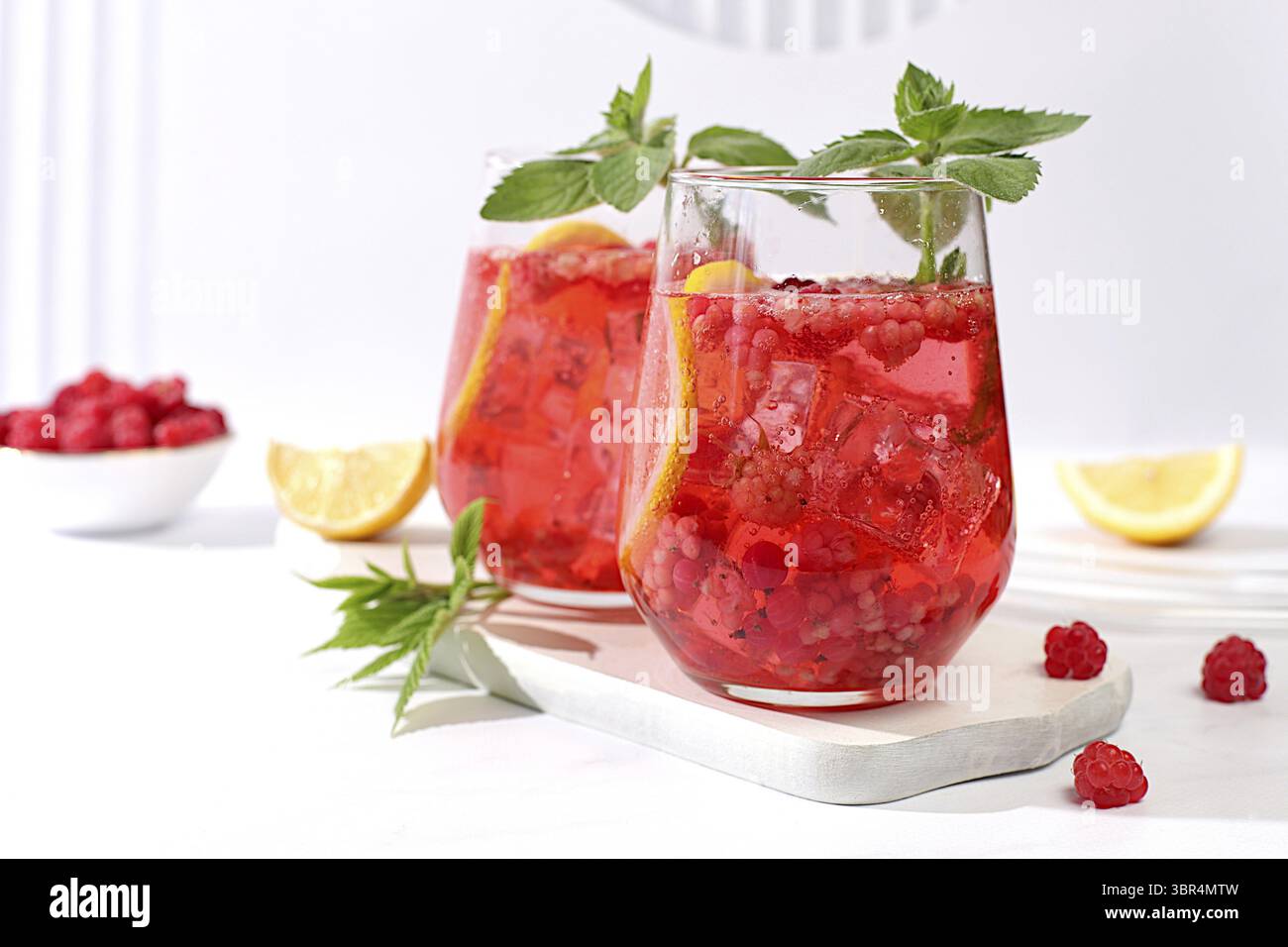 Kalter hausgemachter Limonade-Cocktail, Mojito mit Minze, Himbeere und Früchten auf einem sonnigen Tisch, erfrischendes Sommergetränk Rezept, Detox Diät und Gewichtsverlust c Stockfoto