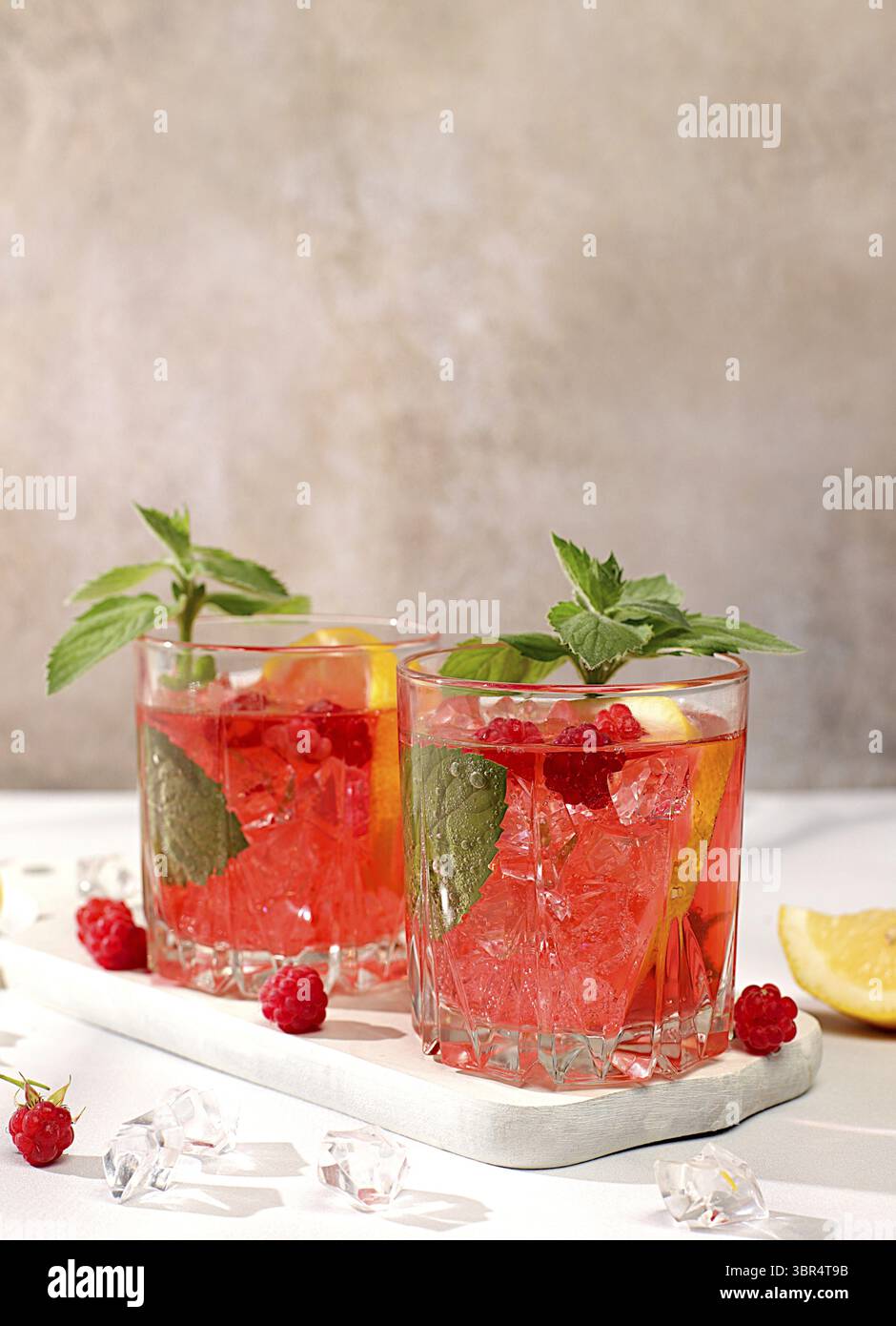 Kalter hausgemachter Limonade-Cocktail, Mojito mit Minze, Himbeere und Früchten auf einem sonnigen Tisch, erfrischendes Sommergetränk Rezept, Detox Diät und Gewichtsverlust c Stockfoto