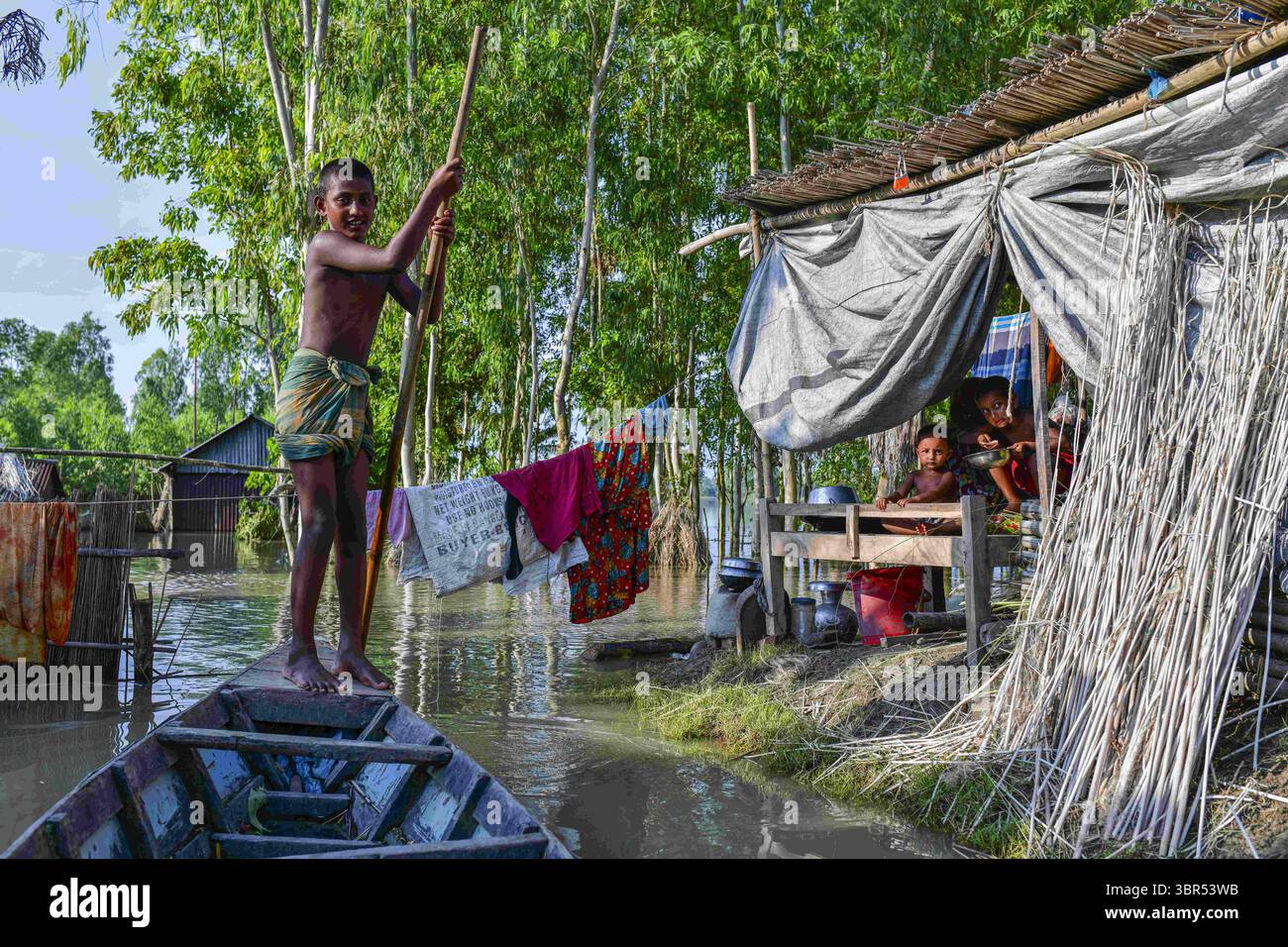 15. Juli 2020, Bogura, Bangladesch: Ein Kind rudert ein Boot in einem überfluteten Gebiet in Bogura. Mehr als vier Millionen Menschen sind von den Monsunfluten in Bangladesch betroffen, wobei ein Drittel des Landes bereits unter Wasser ist, nachdem einige der schwersten Regenfälle seit einem Jahrzehnt stattgefunden haben, sagten Beamte. (Credit Image: © Zabed Hasnain Chowdhury/SOPA Images via ZUMA Wire) Stockfoto