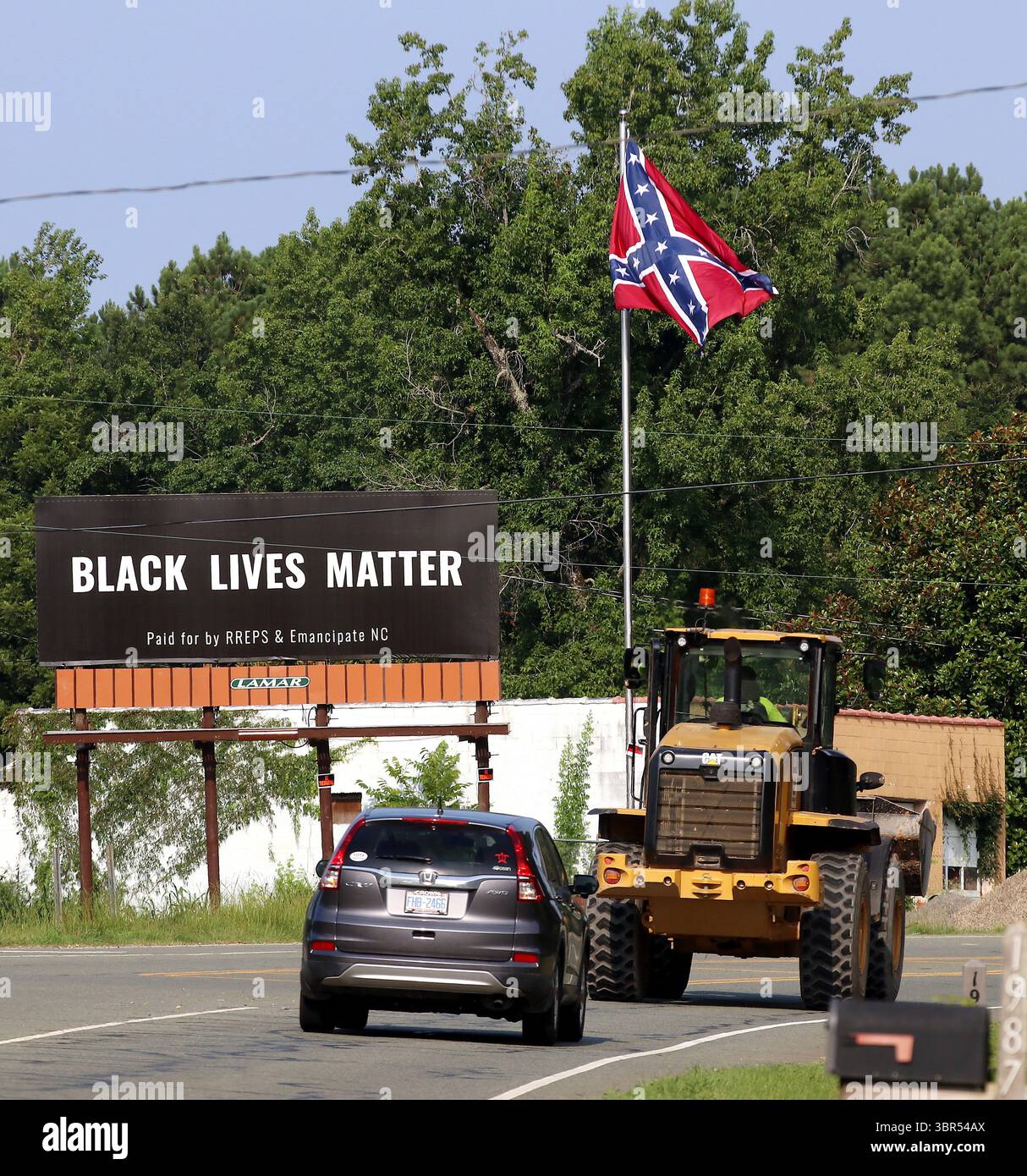 17. Juli 2020 – Pittsboro, North Carolina, USA – am Donnerstag steht neben der Flagge der Konföderierten auf dem US Highway 64 Eine Werbetafel von Black Lives Matter. Eine Online-Spendenaktion half, die Plakatwand in der Nähe zu bezahlen, wo letztes Jahr eine umstrittene Statue der Konföderierten entfernt wurde. Auf der Plakatwand, die ein Jahr lang geöffnet sein wird, steht „Black Lives Matter“ und wurde „bezahlt von RREPS & Emancipate NC“. Nach monatelangen, teils gewalttätigen Protesten entfernten Beamte im November eine Statue der Konföderierten, die mehr als ein Jahrhundert lang vor dem Chatham County Courthouse stand. (Kreditbild: © Bob Karp/ZUMA Wire Stockfoto
