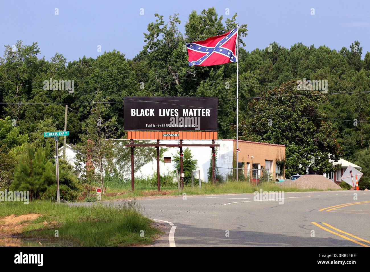 17. Juli 2020 – Pittsboro, North Carolina, USA – am Donnerstag steht neben der Flagge der Konföderierten auf dem US Highway 64 Eine Werbetafel von Black Lives Matter. Eine Online-Spendenaktion half, die Plakatwand in der Nähe zu bezahlen, wo letztes Jahr eine umstrittene Statue der Konföderierten entfernt wurde. Auf der Plakatwand, die ein Jahr lang geöffnet sein wird, steht „Black Lives Matter“ und wurde „bezahlt von RREPS & Emancipate NC“. Nach monatelangen, teils gewalttätigen Protesten entfernten Beamte im November eine Statue der Konföderierten, die mehr als ein Jahrhundert lang vor dem Chatham County Courthouse stand. (Kreditbild: © Bob Karp/ZUMA Wire Stockfoto