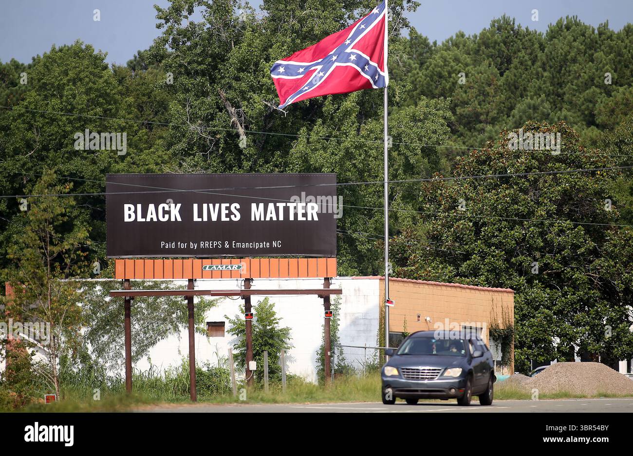 17. Juli 2020 – Pittsboro, North Carolina, USA – am Donnerstag steht neben der Flagge der Konföderierten auf dem US Highway 64 Eine Werbetafel von Black Lives Matter. Eine Online-Spendenaktion half, die Plakatwand in der Nähe zu bezahlen, wo letztes Jahr eine umstrittene Statue der Konföderierten entfernt wurde. Auf der Plakatwand, die ein Jahr lang geöffnet sein wird, steht „Black Lives Matter“ und wurde „bezahlt von RREPS & Emancipate NC“. Nach monatelangen, teils gewalttätigen Protesten entfernten Beamte im November eine Statue der Konföderierten, die mehr als ein Jahrhundert lang vor dem Chatham County Courthouse stand. (Kreditbild: © Bob Karp/ZUMA Wire Stockfoto