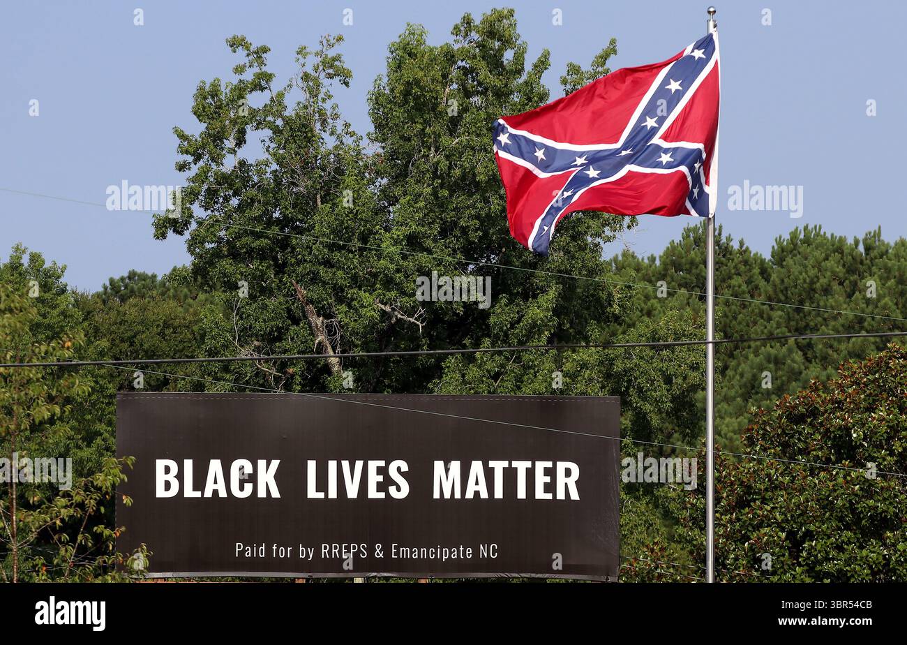 17. Juli 2020 – Pittsboro, North Carolina, USA – am Donnerstag steht neben der Flagge der Konföderierten auf dem US Highway 64 Eine Werbetafel von Black Lives Matter. Eine Online-Spendenaktion half, die Plakatwand in der Nähe zu bezahlen, wo letztes Jahr eine umstrittene Statue der Konföderierten entfernt wurde. Auf der Plakatwand, die ein Jahr lang geöffnet sein wird, steht „Black Lives Matter“ und wurde „bezahlt von RREPS & Emancipate NC“. Nach monatelangen, teils gewalttätigen Protesten entfernten Beamte im November eine Statue der Konföderierten, die mehr als ein Jahrhundert lang vor dem Chatham County Courthouse stand. (Kreditbild: © Bob Karp/ZUMA Wire Stockfoto
