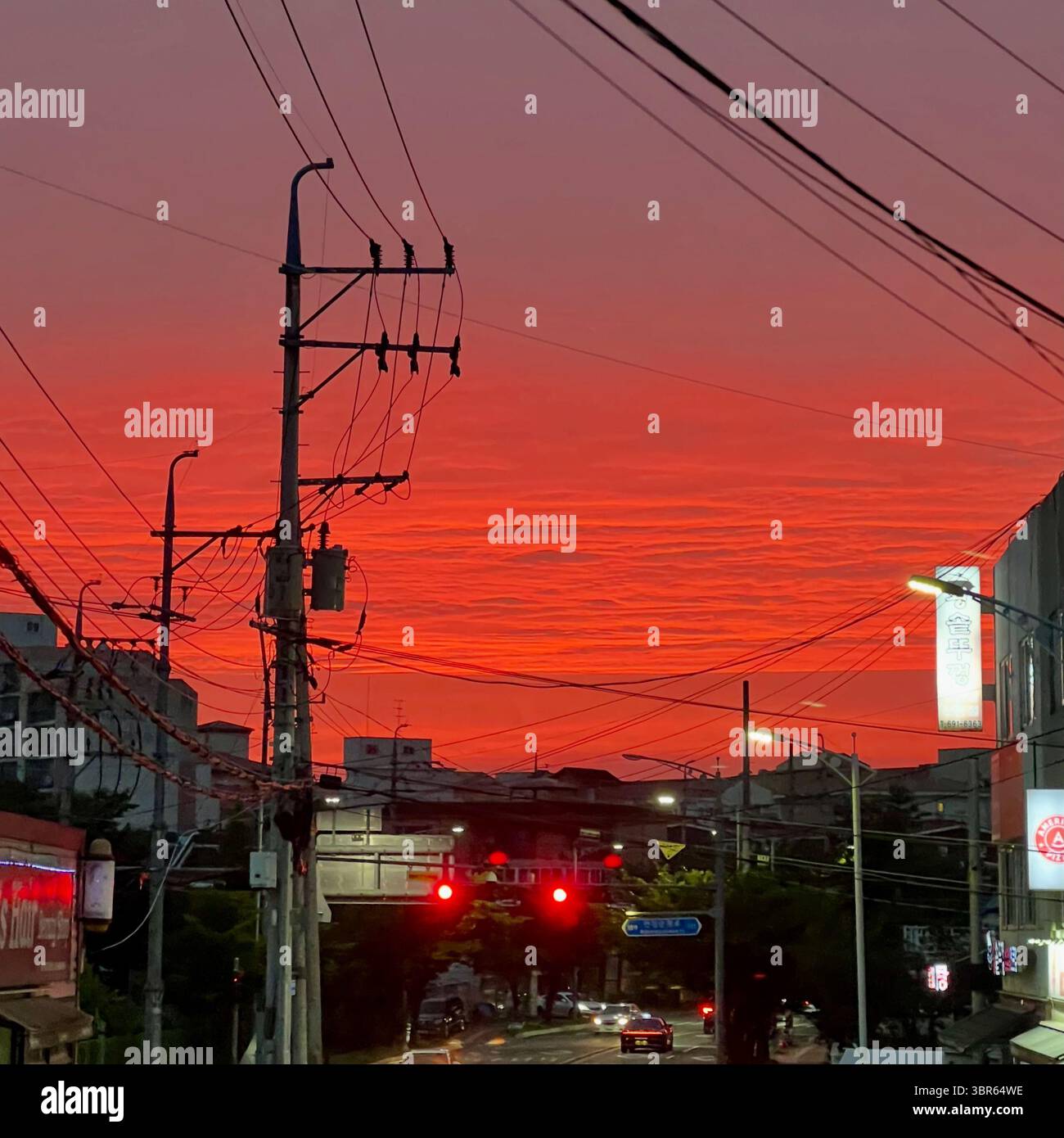 Dramatischer roter Abendhimmel von der Straße auf einem Hügel in Pyeongtaek, Südkorea. - Smartphone-aufgenommenes Stockfoto