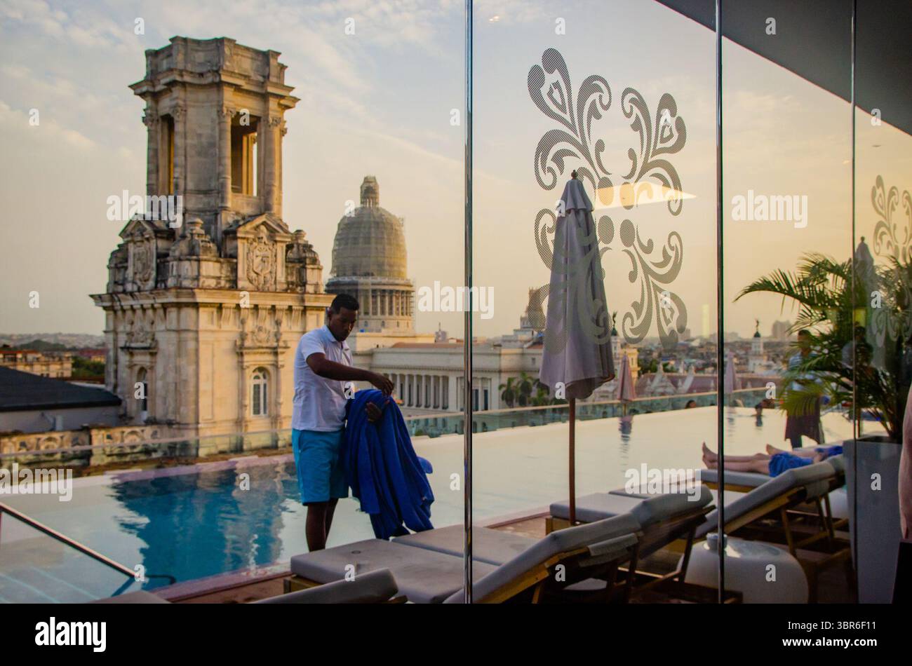 9. August 2018, Havanna, Kuba: UN empleado retira toallas en Ã¡rea de piscina al final del dÃ­a en el Hotel Gran Manzana Kempinski, en La Habana, Kuba. El Manzana es propiedad de empresas que pertenecen al ministerio de defensa cubano, sancionadas por el depertamento del tesoro nosteamericano. (Kreditbild: © Carlos Escalona/ZUMA Wire) Stockfoto