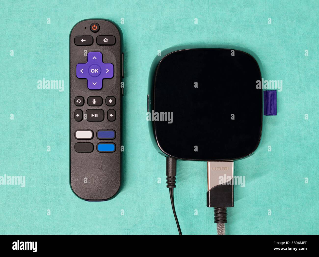 Streaming-Media-Player mit Fernbedienung auf blauem Hintergrund, flach gelegt. Stockfoto