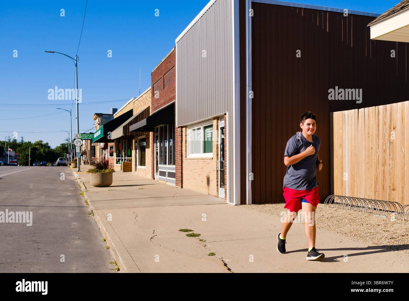 3. August 2020, Jewell, Iowa, USA: Eine Person joggt die Main Street in Jewell am Montag Morgen. Der einzige Supermarkt in Jewell, einer kleinen Gemeinde im Zentrum von Iowa, wurde 2019 geschlossen. Es diente vier Gemeinden im Umkreis von 20 Meilen um Jewell. Einige Bewohner der Stadt gründeten eine Genossenschaft, um den Laden wieder zu eröffnen. Sie verkauften Aktien an die Co-op und hielten Spendenaktionen im Frühjahr ab. Die Organisatoren sammelten etwa 225.000 US-Dollar und kauften den Laden, der am 8. Juli seine „weiche Öffnung“ hatte. Der Laden feierte seine offizielle Wiedereröffnung am 3. August. Vor der Wiedereröffnung war Jewell eine „Essenswüste“ für se gewesen Stockfoto