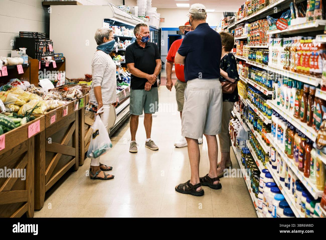 3. August 2020, Jewell, Iowa, USA: Shoppers treffen sich in einem Gang auf dem Jewell Market. Der einzige Supermarkt in Jewell, einer kleinen Gemeinde im Zentrum von Iowa, wurde 2019 geschlossen. Es diente vier Gemeinden im Umkreis von 20 Meilen um Jewell. Einige Bewohner der Stadt gründeten eine Genossenschaft, um den Laden wieder zu eröffnen. Sie verkauften Aktien an die Co-op und hielten Spendenaktionen im Frühjahr ab. Die Organisatoren sammelten etwa 225.000 US-Dollar und kauften den Laden, der am 8. Juli seine „weiche Öffnung“ hatte. Der Laden feierte seine offizielle Wiedereröffnung am 3. August. Vor der Wiedereröffnung war Jewell sieben Jahre lang eine „Essenswüste“ Stockfoto