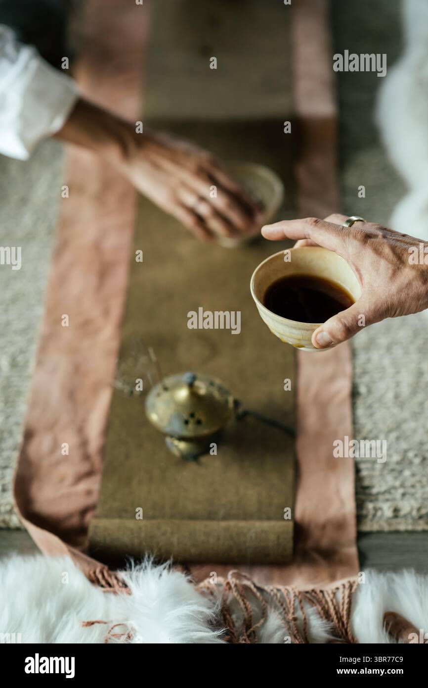 Hands Sharing Tea – intime und heilige Teezeremonie Stockfoto