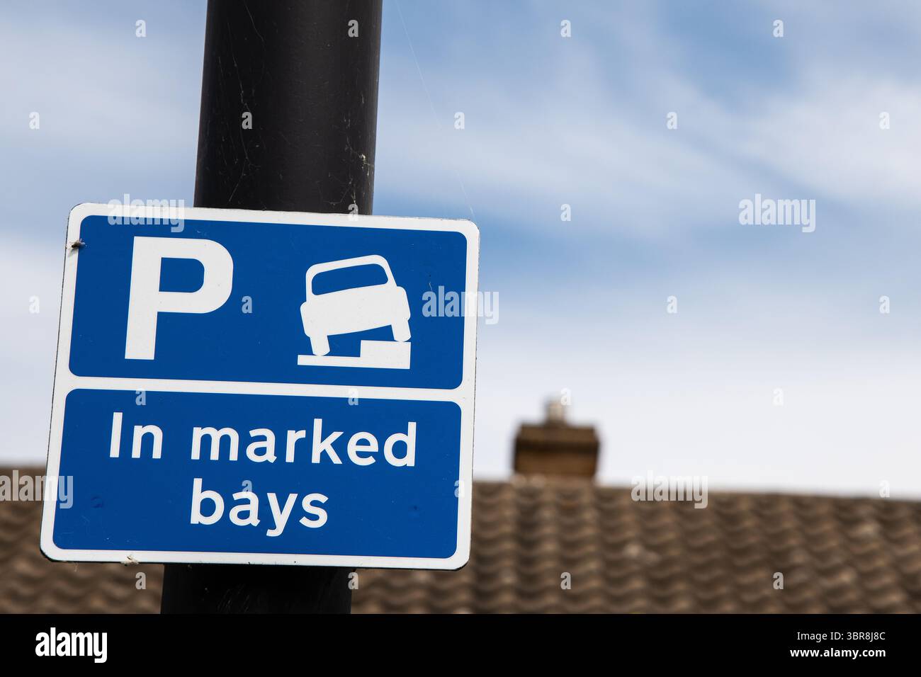 Blaues Parkschild mit einem weißen „P“, eine Fahrzeuggrafik auf einem Bordstein und Text mit der Aufschrift „in markierten Buchten“ – weist nur auf eingeschränktes Parken innerhalb der dafür vorgesehenen AR hin Stockfoto