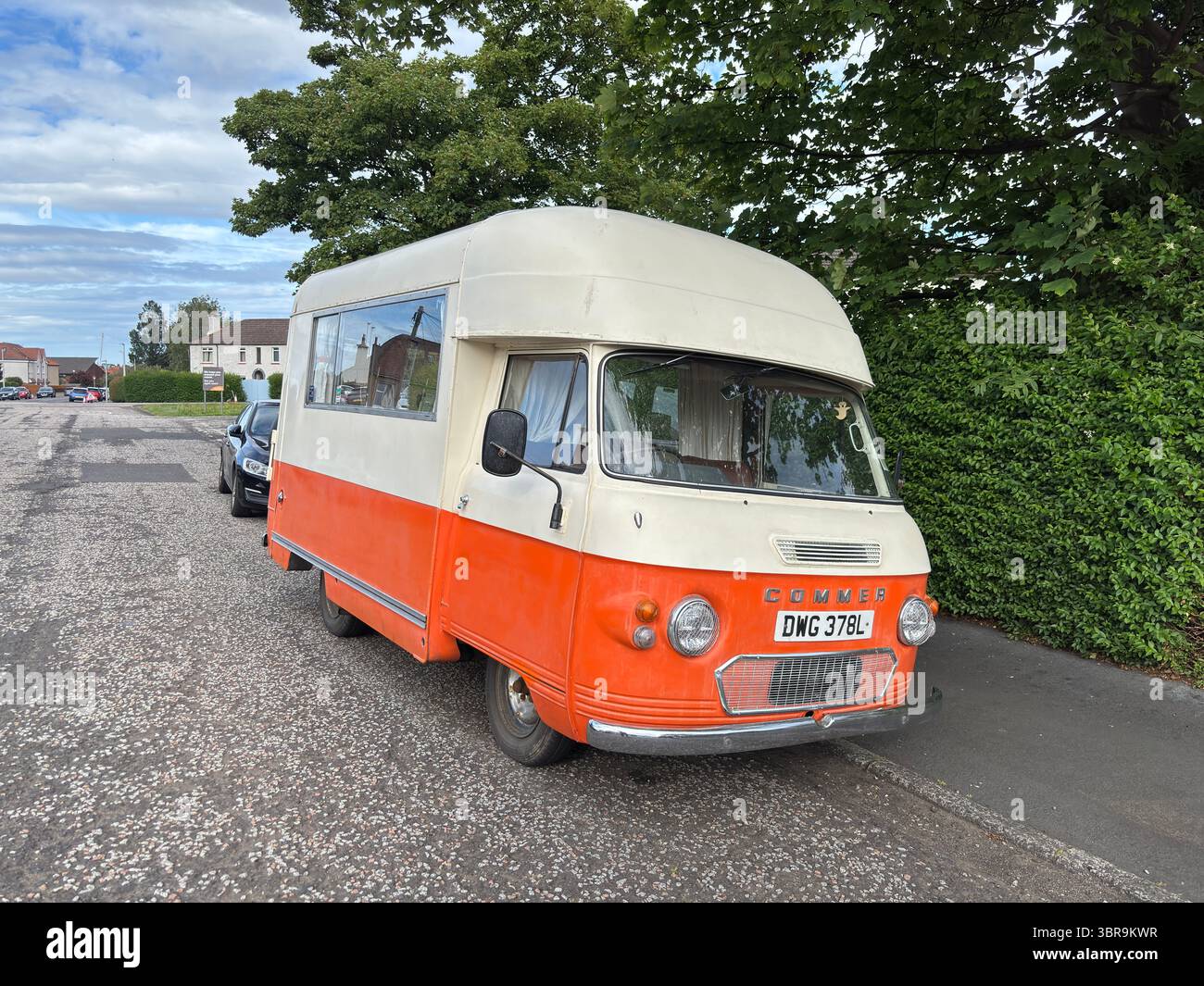Der Vintage-Wohnwagen Commer in Creme und Orange parkt auf einer Straße in Edinburgh und verbindet Retro-Charme mit der architektonischen Kulisse der Stadt Stockfoto
