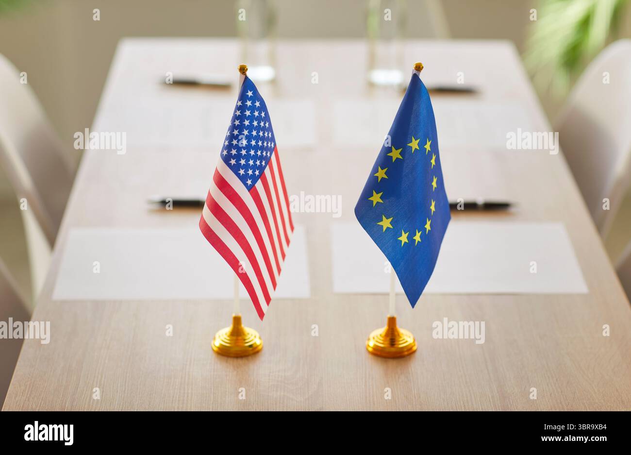 Konferenzraum mit den Fahnen der USA und der Europäischen Union auf dem Tisch, ohne dass Menschen für Zusammenarbeit stehen Stockfoto