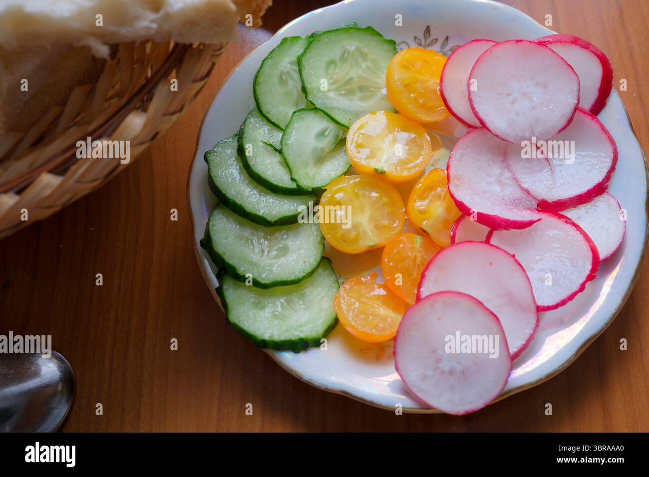 Leuchtende Gurkenscheiben, Radieschen und gelbe Tomaten zeigen die Schönheit der Natur. Stockfoto