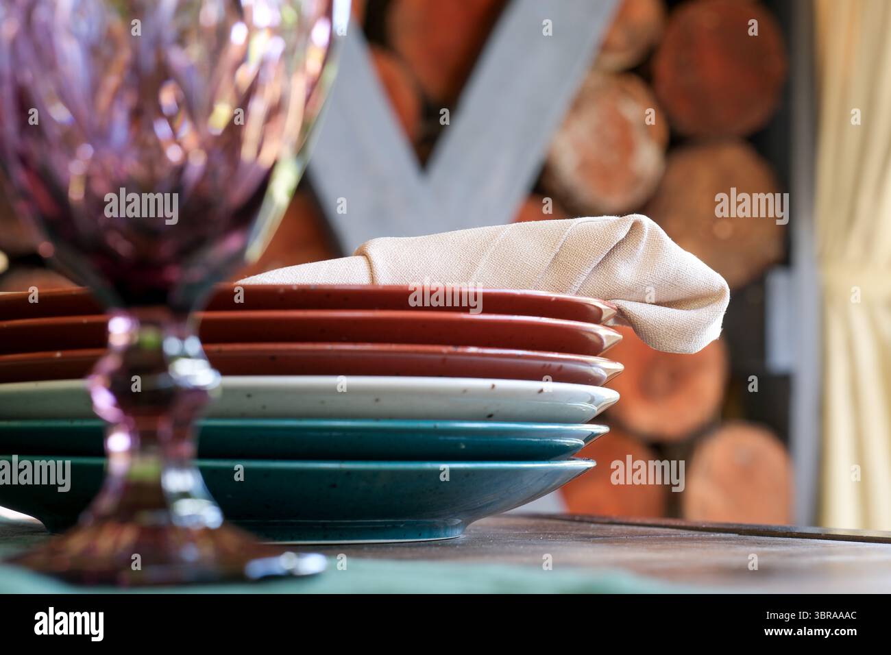 Bunte Teller und ein stilvolles Glas erwarten Sie in einer warmen Atmosphäre. Stockfoto