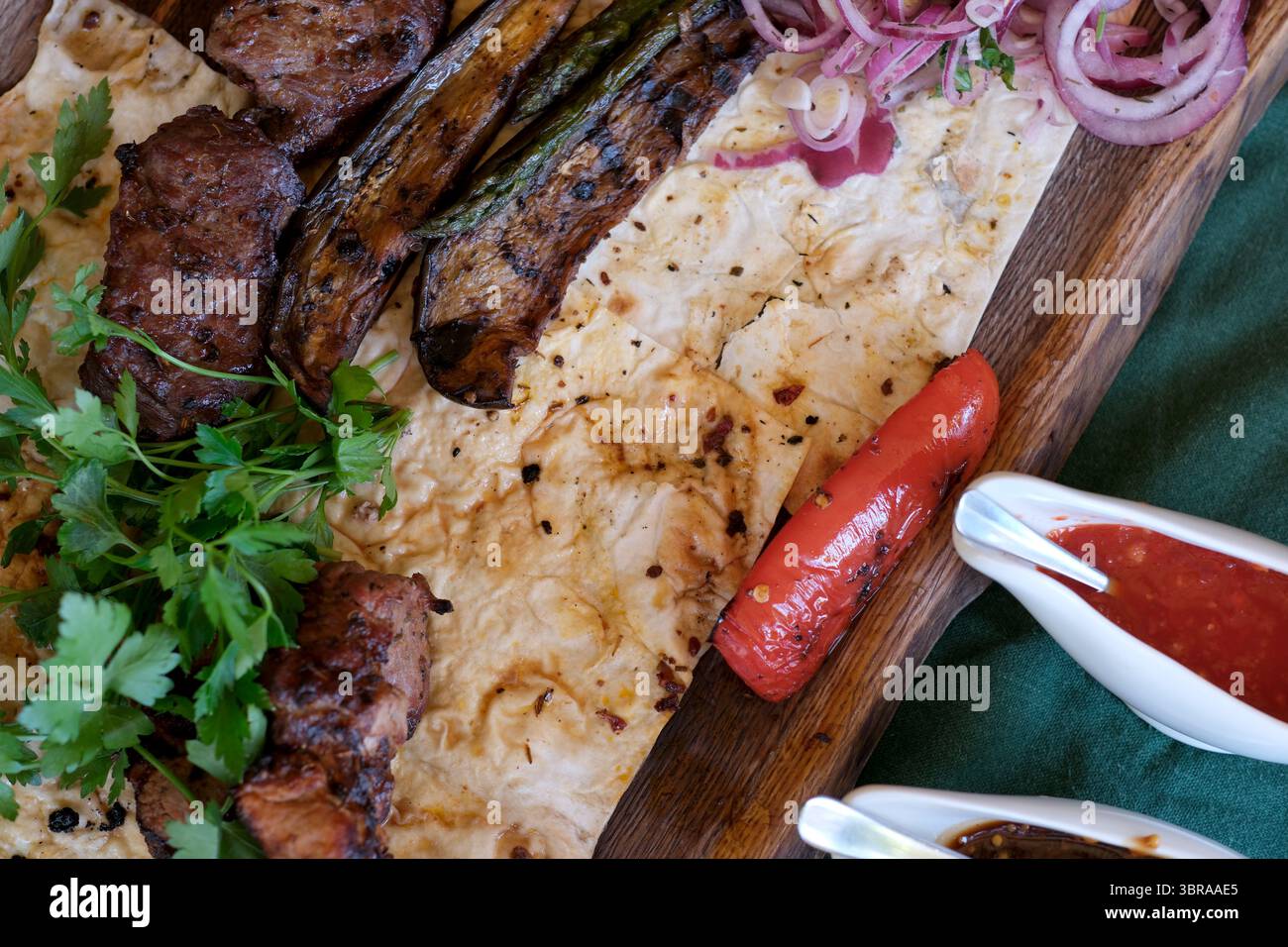 Ein köstliches Aufstrich zeigt gegrilltes Fleisch, Gemüse und frische Kräuter, die Sie genießen können. Stockfoto