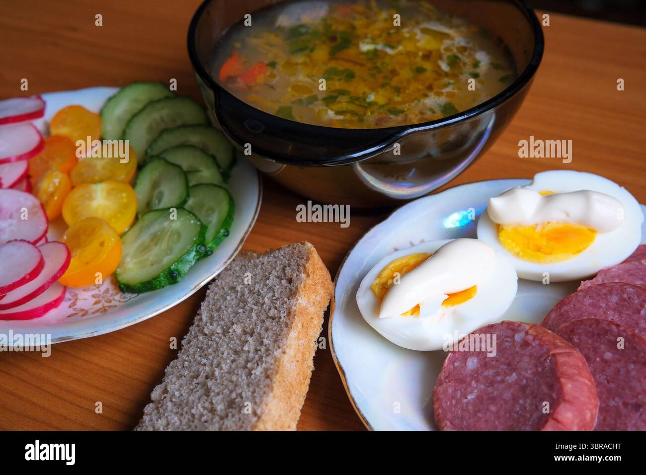 Genießen Sie eine warme Schüssel Suppe, begleitet von lebendigem Gemüse und Eiern Stockfoto